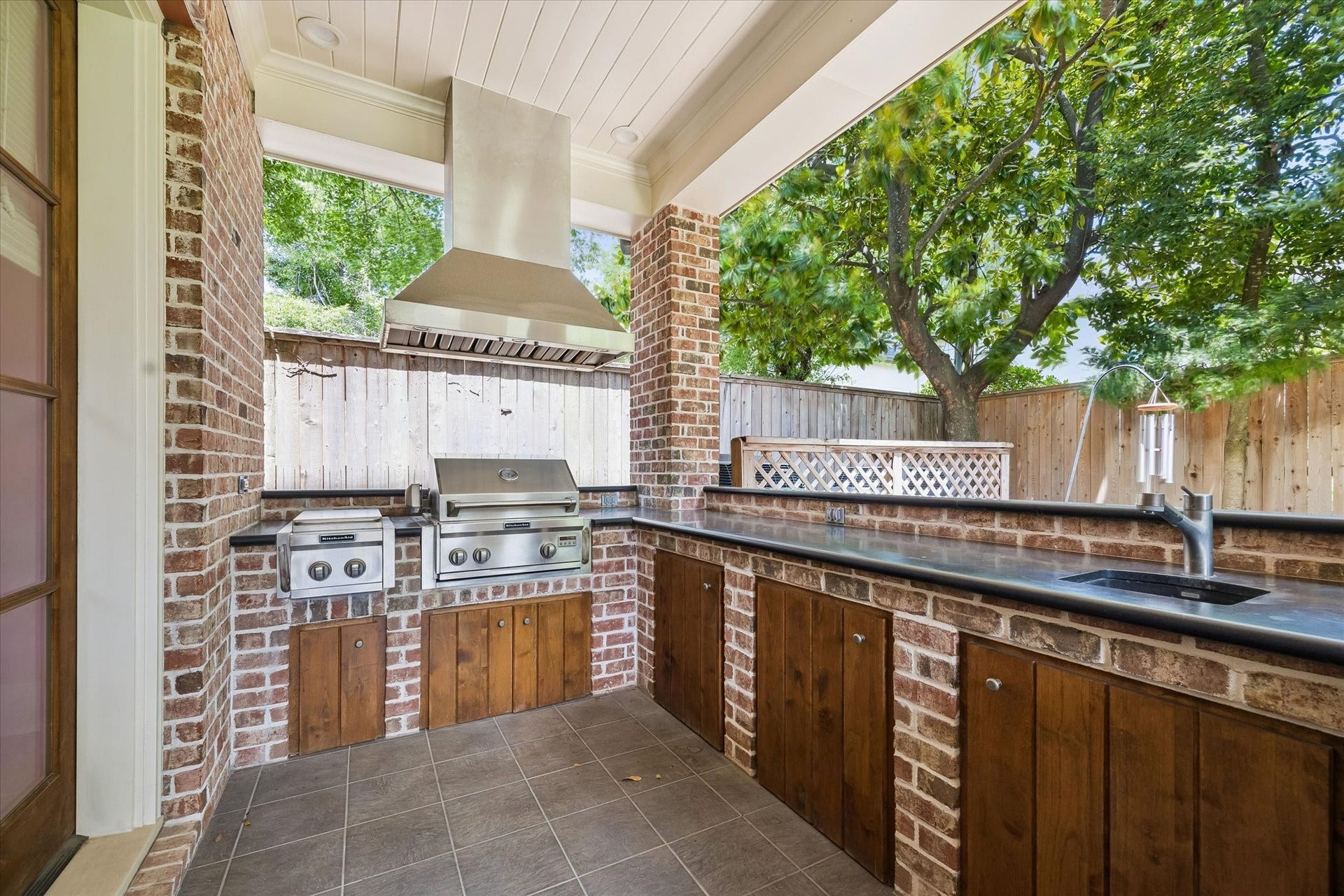 Summer kitchen underneath a covered porch outside.