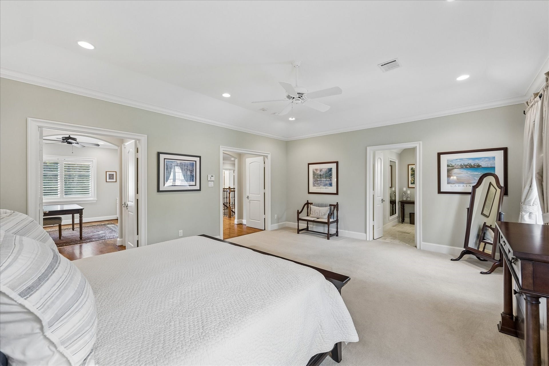 View from the primary suite showcasing the seating area and glimpses into the home office, hallway and bath.