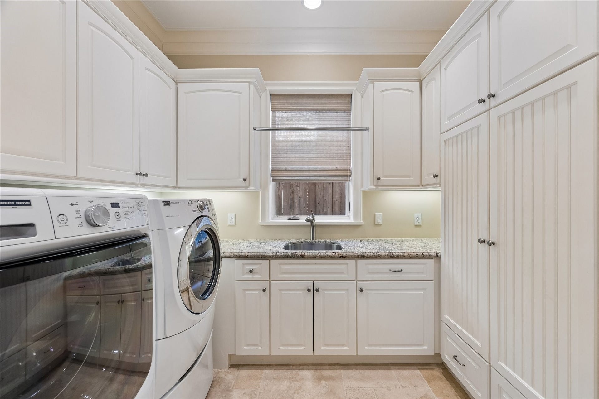 Located on the first floor, the utility room has enclosed storage cabinets. Both sets of washer/dryers are included. Stackable units located in primary closet.