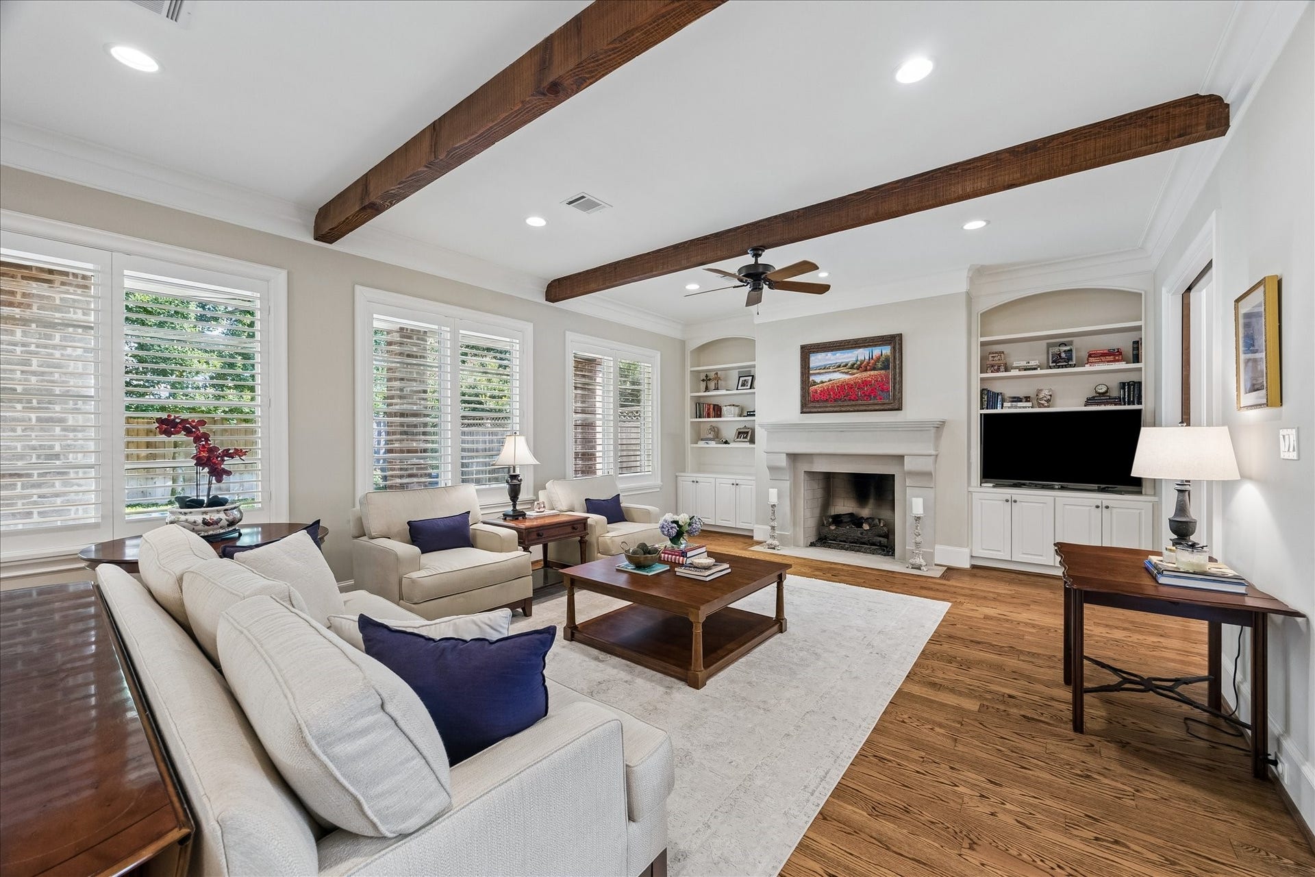 Huge living room with cast stone fireplace, wood beams, built-in shelves and storage cabinets.