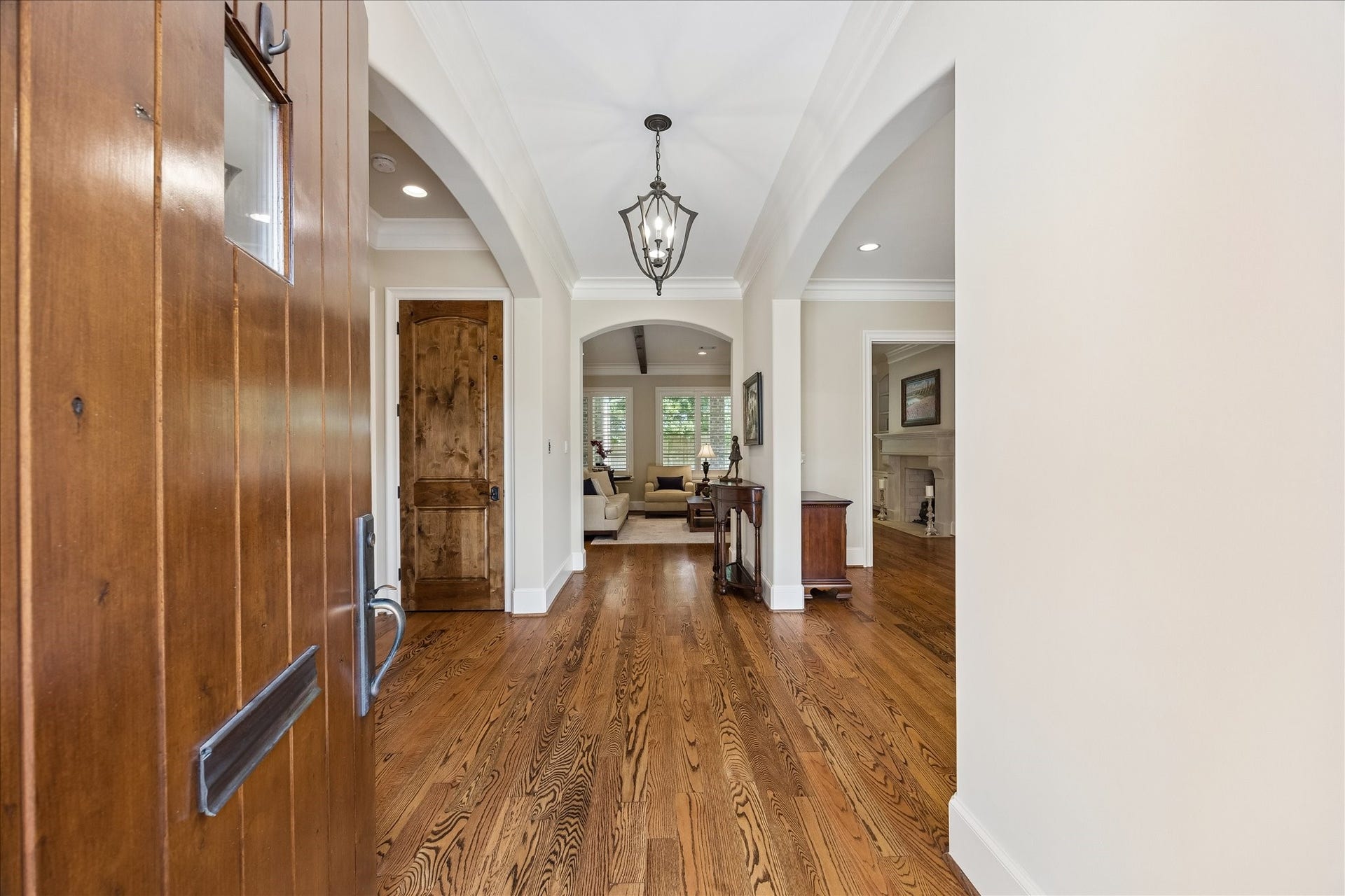 Formal entry way showcasing the hardwood floors and lovely archways. The door pictured is the first floor entry to the elevator.
