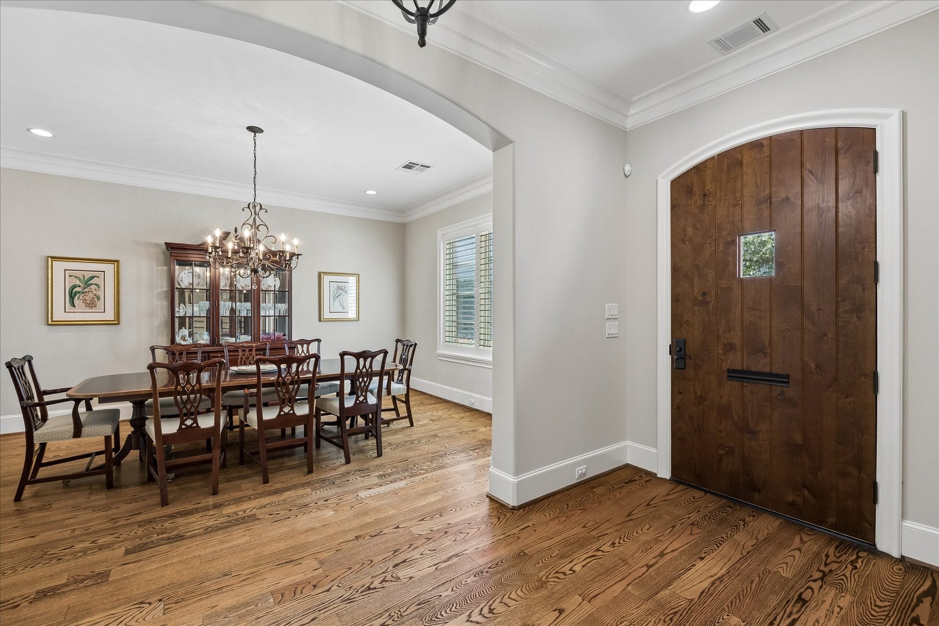 View from the entry way into the generously sized dining room with both recessed lighting and a chandelier.