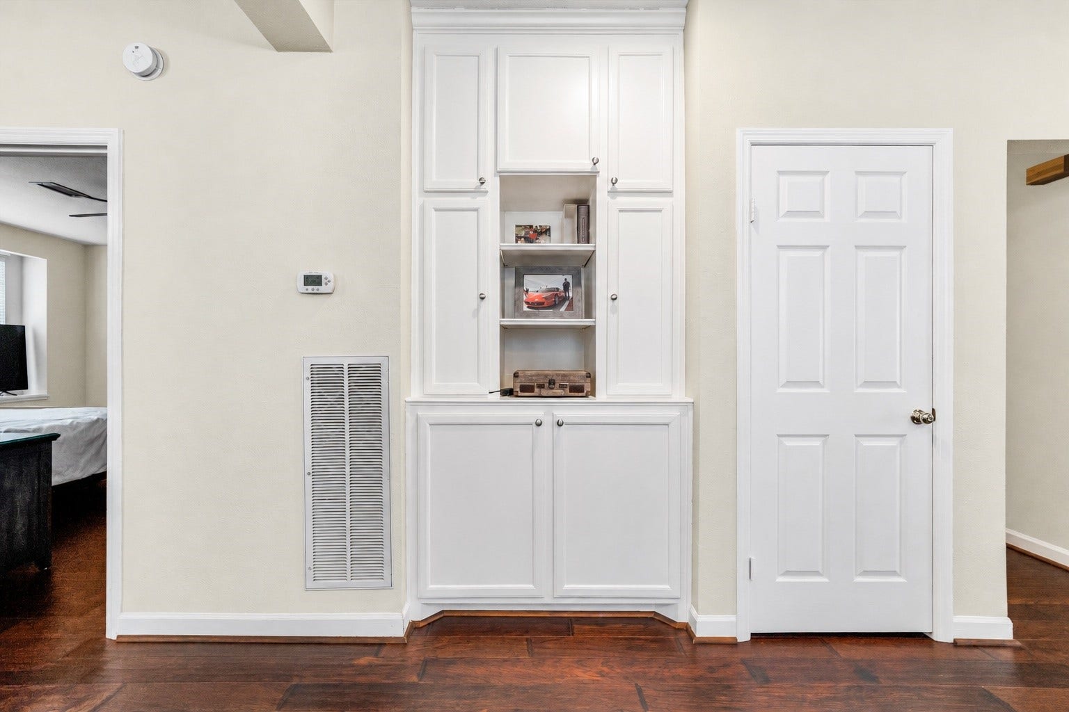 11 Sweetdream Place, The Woodlands, TX 77381 Elegant built-in cabinetry offers extra storage and display space, complemented by rich hardwood flooring and a clean, neutral palette for a sophisticated touch.