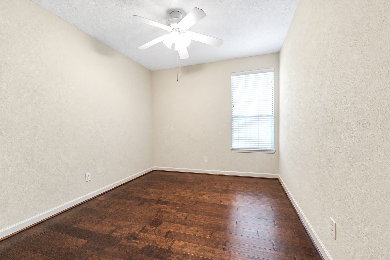 11 Sweetdream Place, The Woodlands, TX 77381 Bright and cozy dining with warm hardwood floors, a ceiling fan, and ample natural light from a large window.