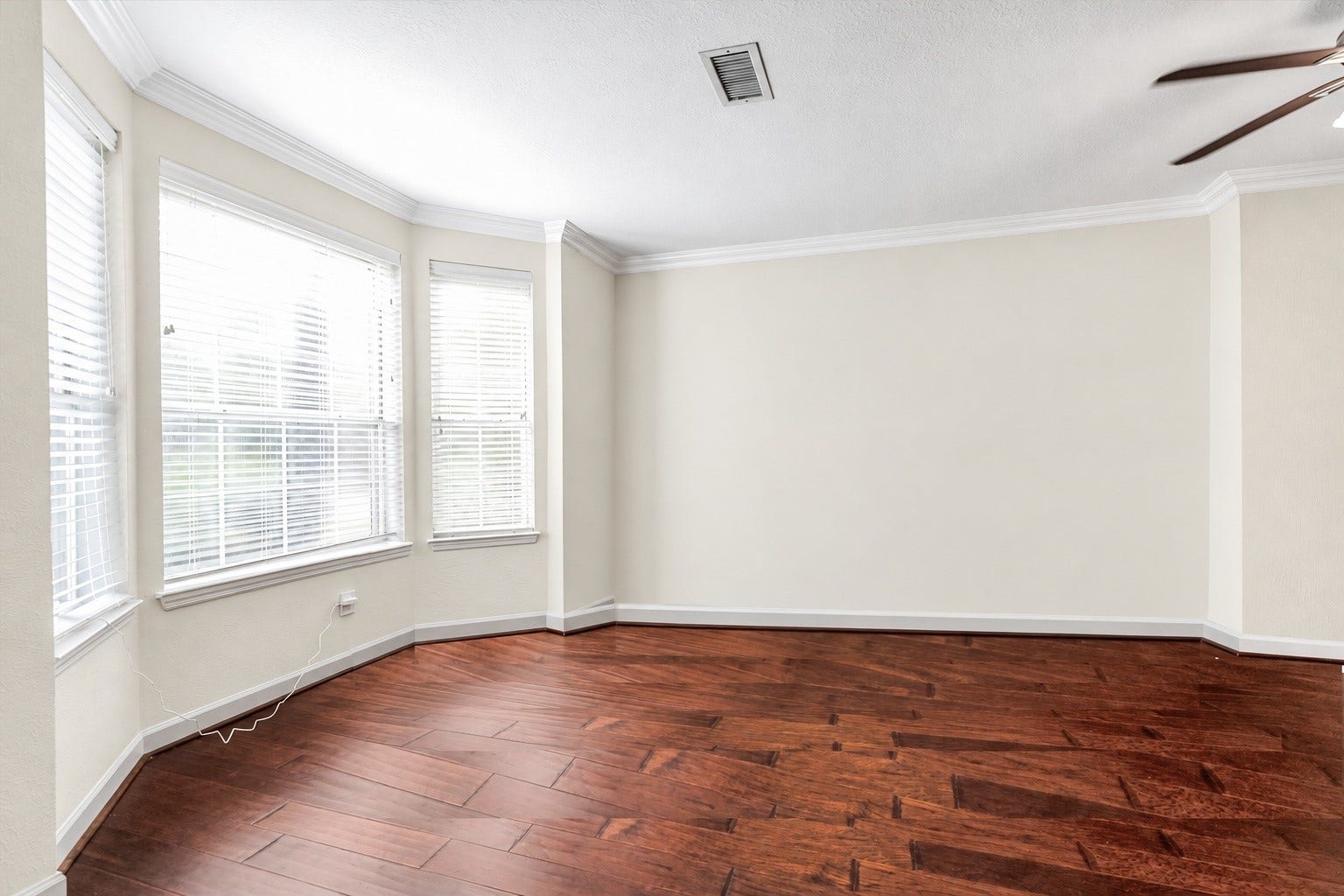 11 Sweetdream Place, The Woodlands, TX 77381 Bright and inviting room with rich wood flooring, large windows for natural light, and elegant crown molding. It is a flex area located at the front and can be used as an office or formal living.