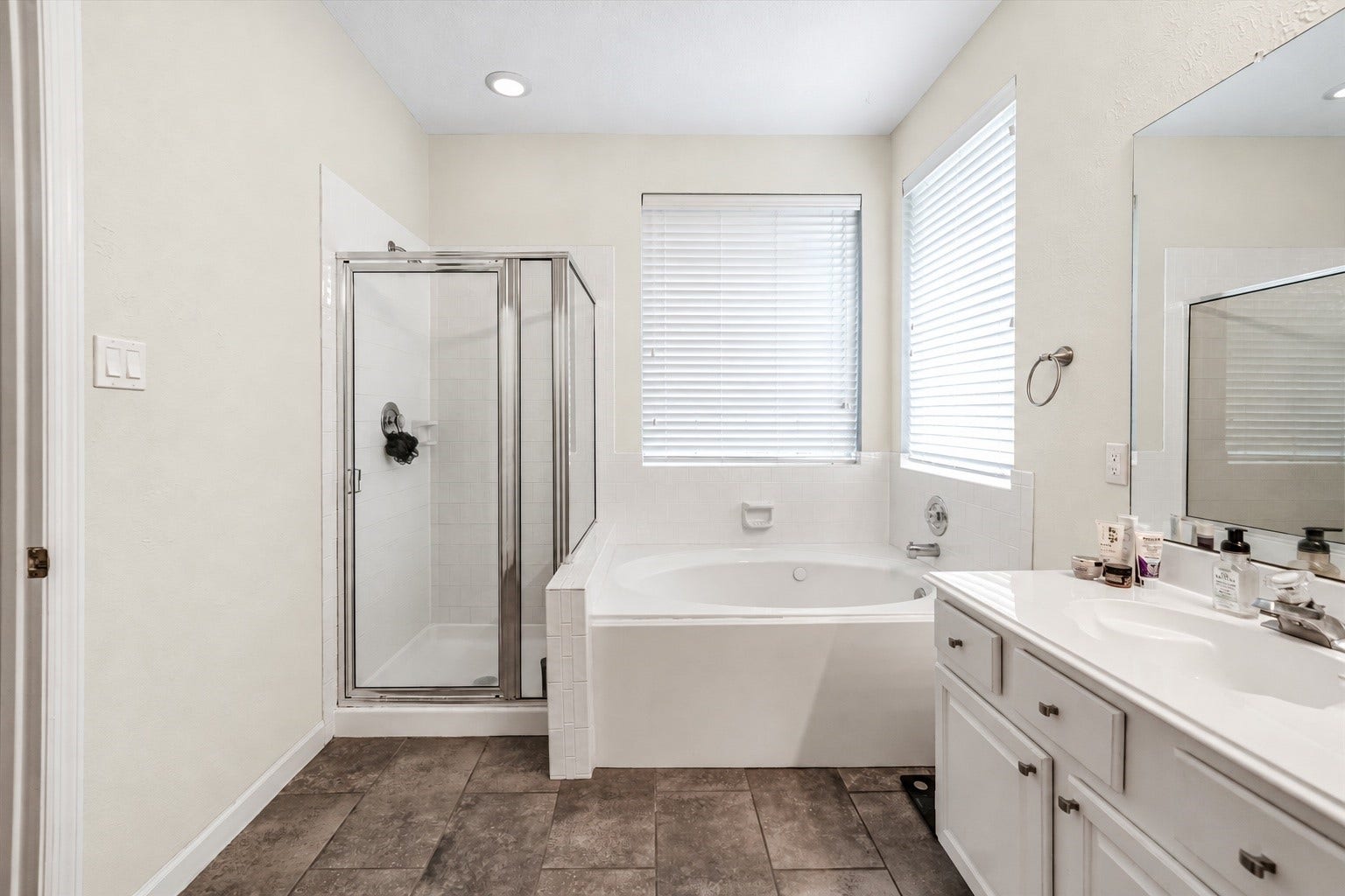 11 Sweetdream Place, The Woodlands, TX 77381 Spacious main bathroom featuring a luxurious soaking tub, separate glass-enclosed shower, and ample natural light, complemented by a sleek vanity with plenty of storage.