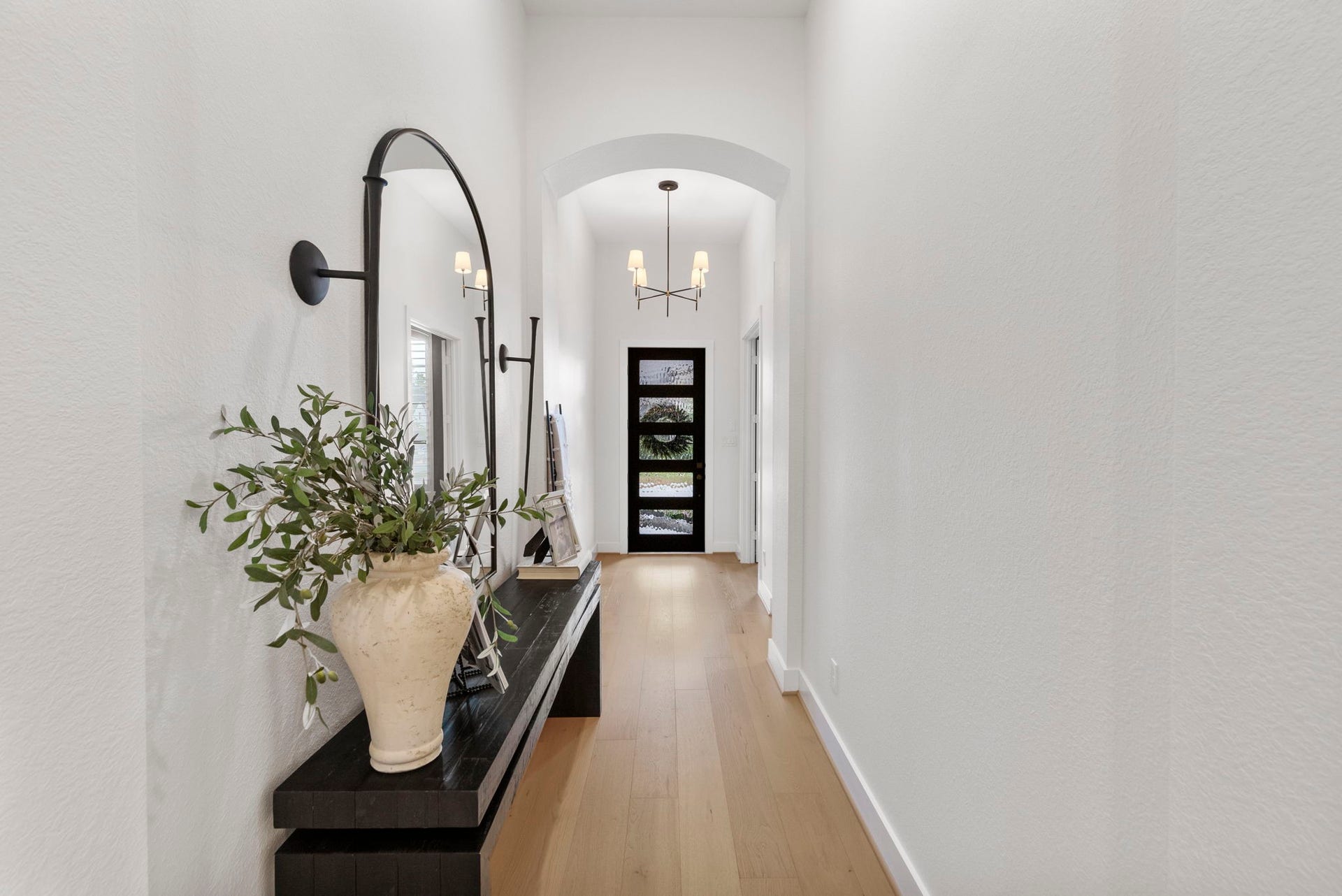 18030 Blu Terrace Drive, Conroe, TX 77302 Inviting entry hallway with arched details, hardwood floors, and designer lighting leading to open living.