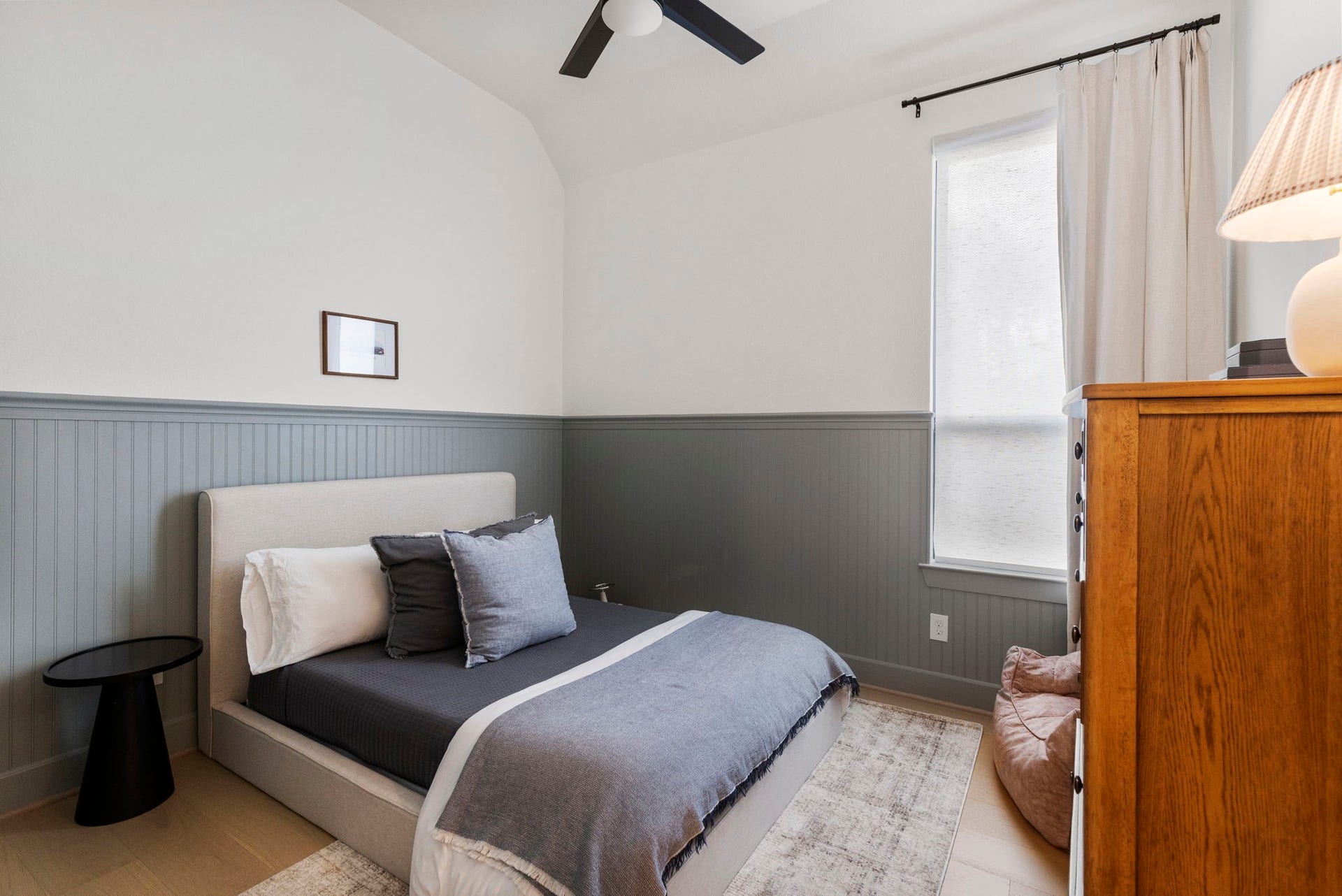 18030 Blu Terrace Drive, Conroe, TX 77302 Bright secondary bedroom featuring stylish wainscoting, tall ceilings, and a large window for natural light.