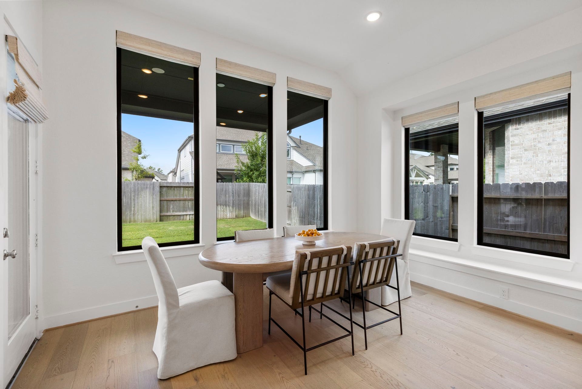 18030 Blu Terrace Drive, Conroe, TX 77302 Breakfast nook showcases oversized windows, custom shades, and airy sightlines to the covered patio.