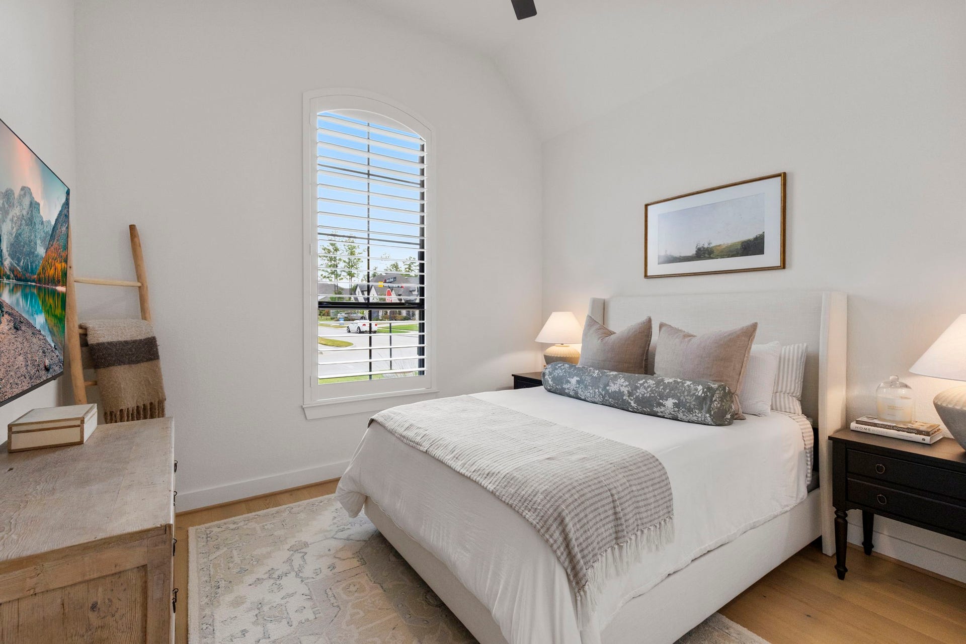 18030 Blu Terrace Drive, Conroe, TX 77302 Bright secondary bedroom featuring hardwood floors, tall ceilings, and an arched window with plantation shutters.