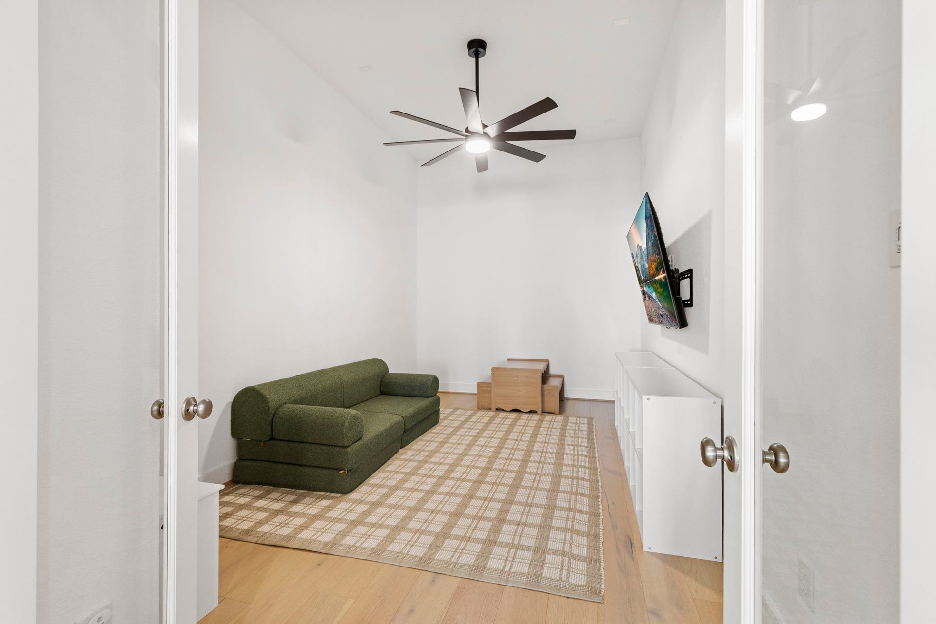 18030 Blu Terrace Drive, Conroe, TX 77302 Private game room with double doors, hardwood floors, and a sleek modern ceiling fan.