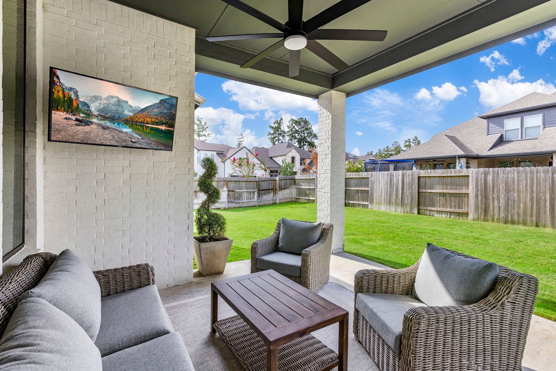 18030 Blu Terrace Drive, Conroe, TX 77302 Extended covered patio with ceiling fan opens to a fenced backyard, perfect for outdoor living.