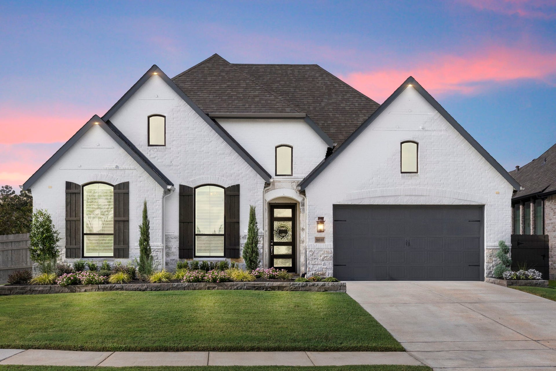 18030 Blu Terrace Drive, Conroe, TX 77302 Crisp white brick exterior, arched windows, and a spacious two-car garage with standout curb appeal.