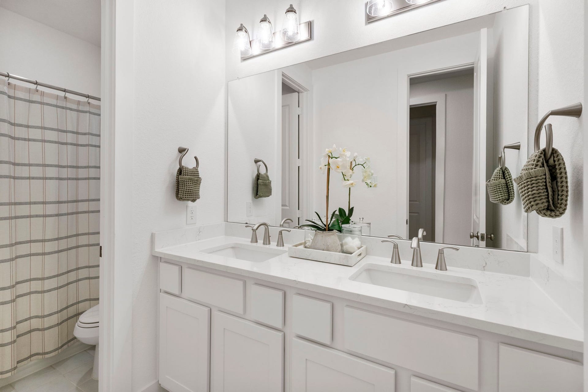 18030 Blu Terrace Drive, Conroe, TX 77302 Bright bathroom with dual-sink vanity, quartz-style counters, oversized mirror, and sleek brushed-nickel lighting.