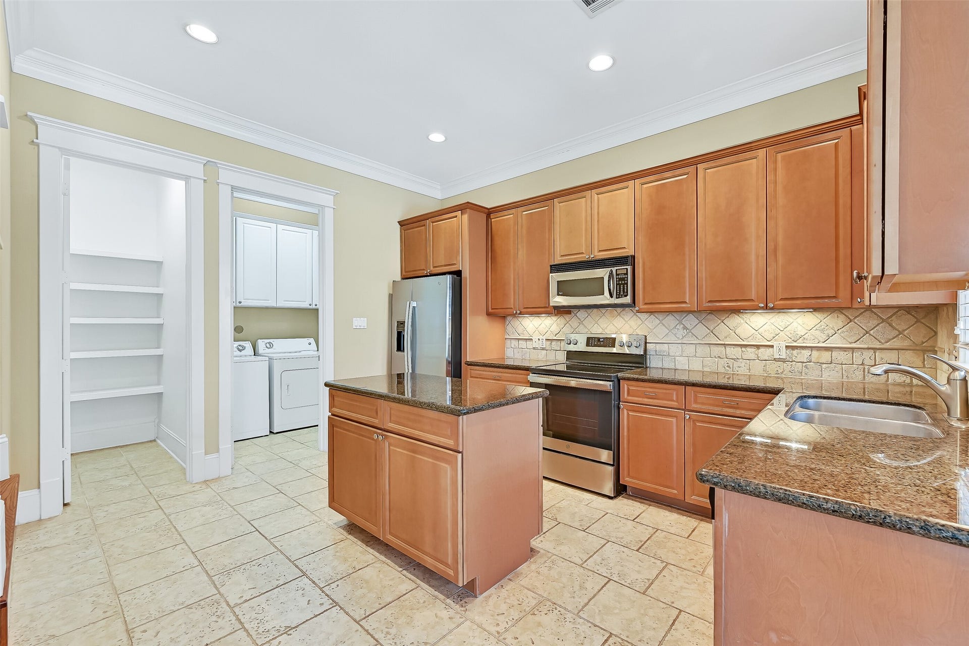 6 Barque Lane, Galveston, TX 77554 Updated kitchen with ample maple cabinetry. Walk-in pantry is to the left, while the door on the Right accesses the laundry & garage.