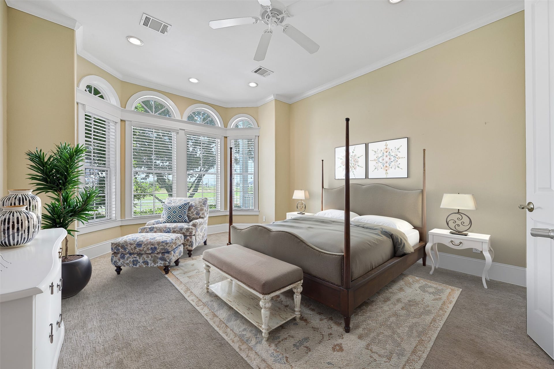 6 Barque Lane, Galveston, TX 77554 Welcome to the light and airy Primary en-suite with plush carpeting and rows of windows allowing in so much natural light and views of the golf course. This photo is virtually-staged.