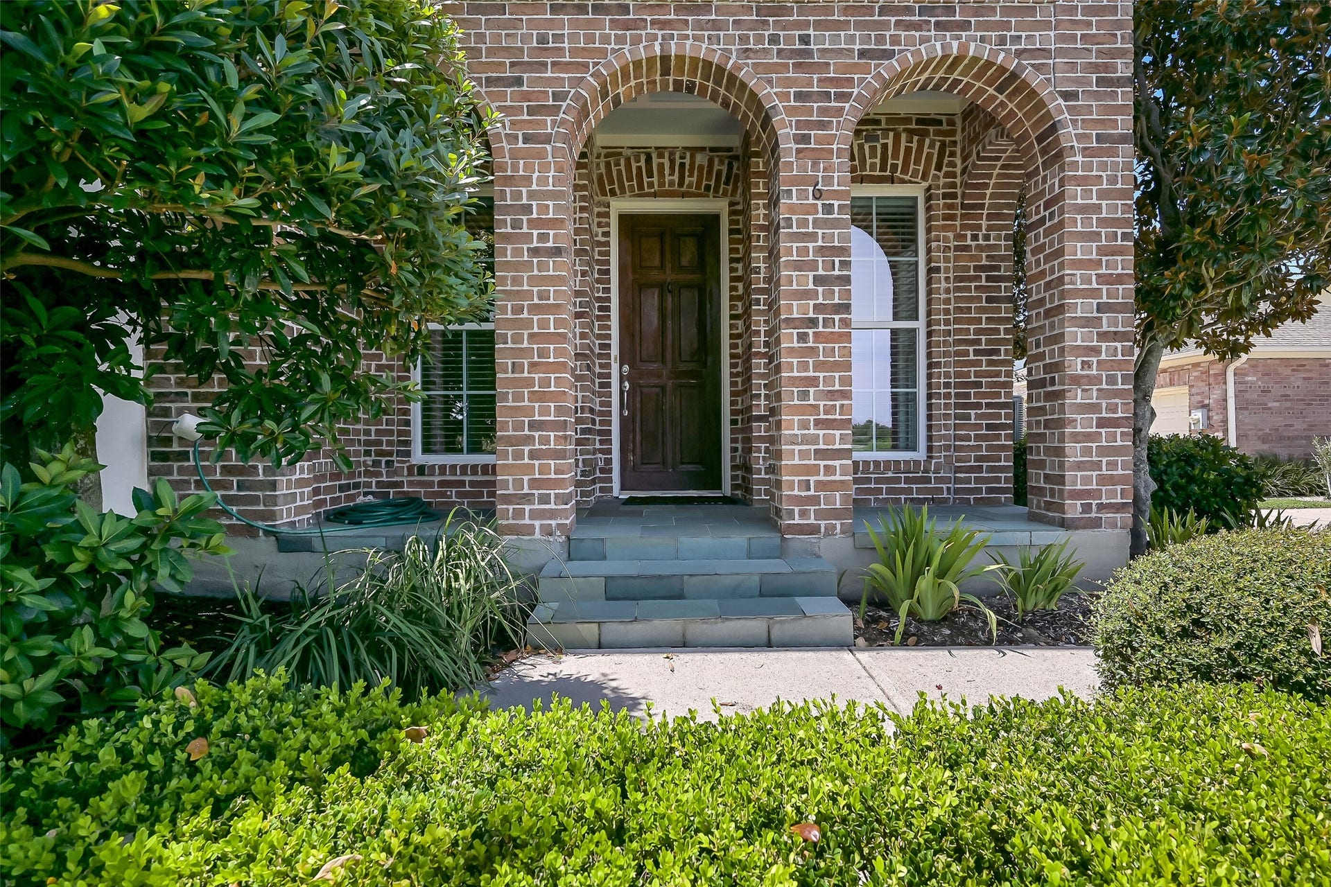 6 Barque Lane, Galveston, TX 77554 Beautiful landscaping envelopes the townhome. This is taken care of by the association - great for those seeking worry free living!