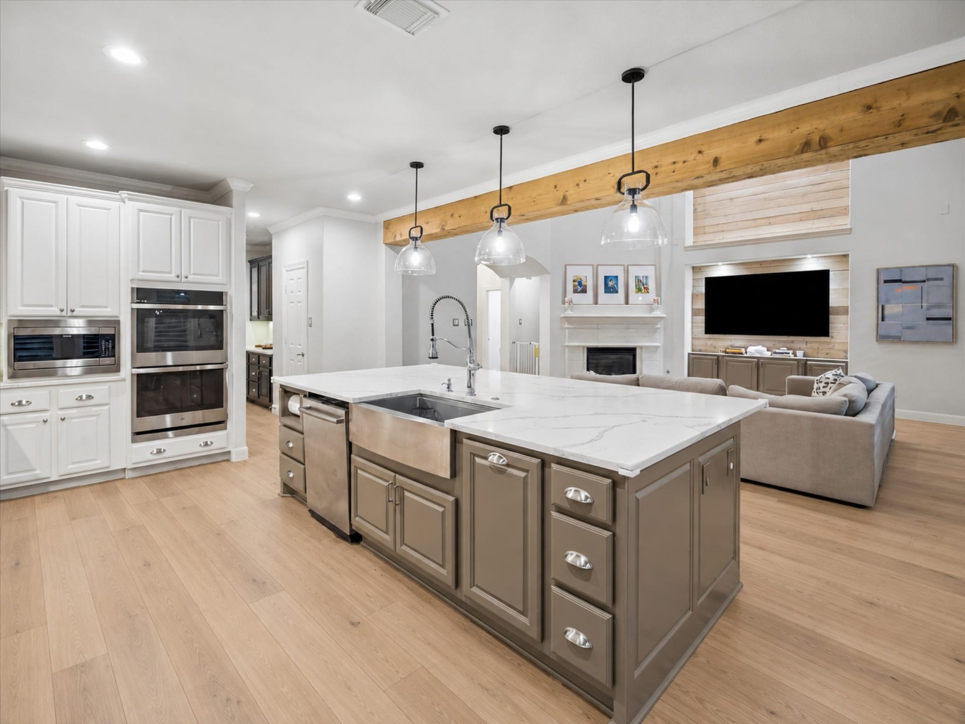 7922 EMERALD HAVEN DRIVE, Sugar Land, TX 77479 OVERSIZED ISLAND WITH GENEROUS STORAGE, A FARMHOUSE SINK, AND CLEAR SIGHTLINES INTO THE TWO-STORY FAMILY ROOM.