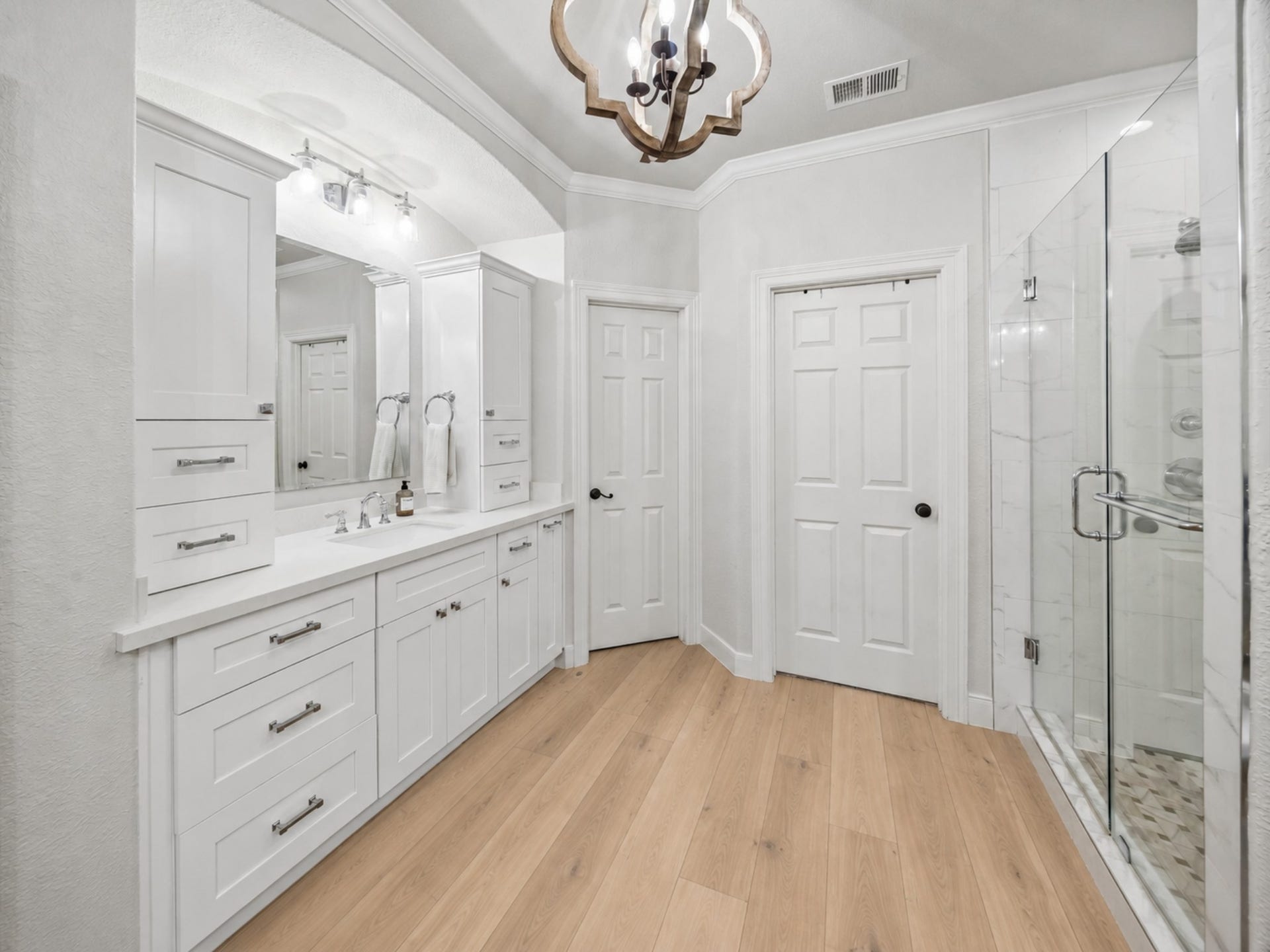 7922 EMERALD HAVEN DRIVE, Sugar Land, TX 77479 THE PRIMARY BATH INCLUDES A LONG VANITY WITH BUILT-IN STORAGE AND A FRAMELESS GLASS SHOWER WITH TILE SURROUND.