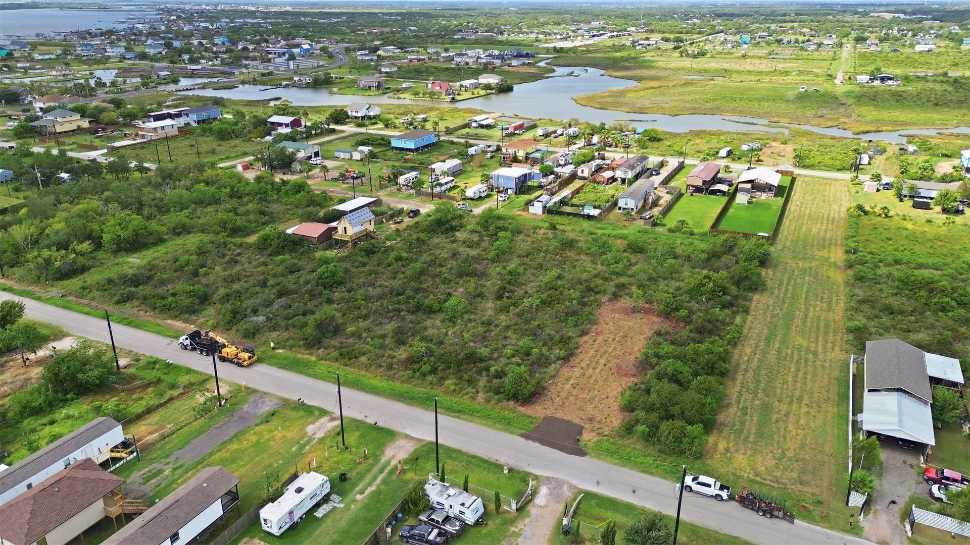 17 W Street, San Leon, TX 77539 Wide aerial showing the property with the winding tidal waterway and marsh beyond. It highlights the coastal setting and open surroundings.