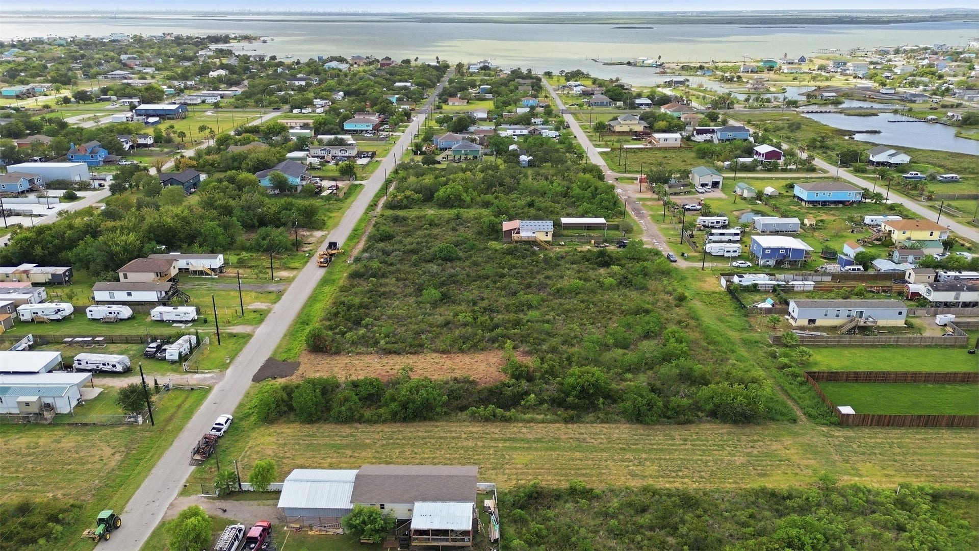 17 W Street, San Leon, TX 77539 Looking straight down the paved 17th street toward the water. Tidal inlets are visible on the right, and the open lot is in the center of the frame.