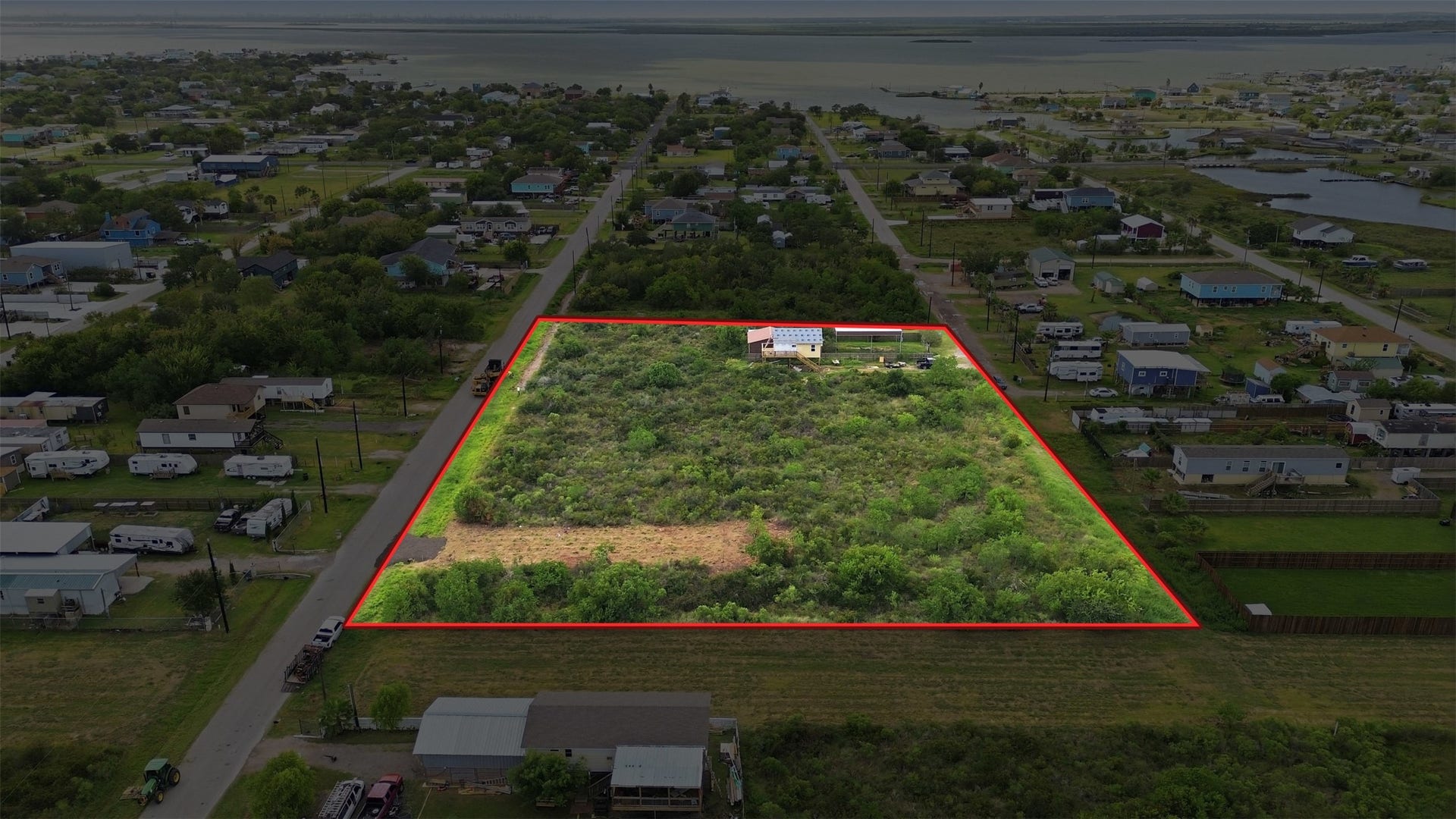 17 W Street, San Leon, TX 77539 Aerial with a red outline marking the approximate property boundary. The bay and tidal waterways are visible beyond.