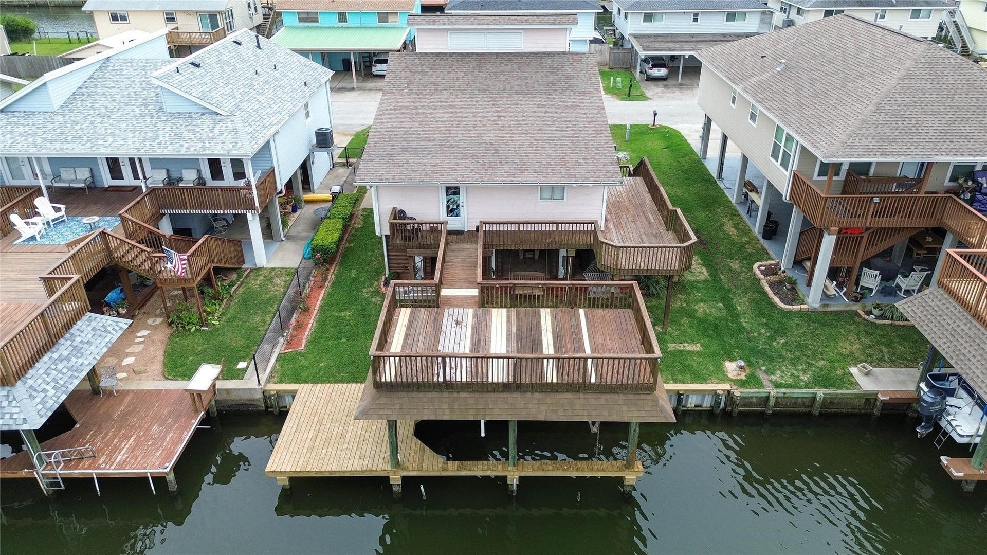 1031 Redfish Street, Bayou Vista, TX 77563 Waterfront home with multi-level wooden decks and a private dock, offering direct canal access. Ideal for boating enthusiasts and outdoor relaxation.
