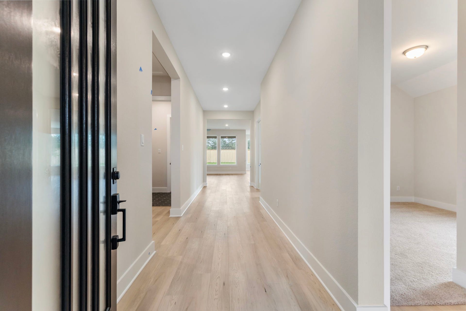 8143 Fenway Heights Dr, The Woodlands, TX 77389 Inviting entryway with light flooring, recessed lighting, and a view to the backyard, creating a bright and welcoming atmosphere.