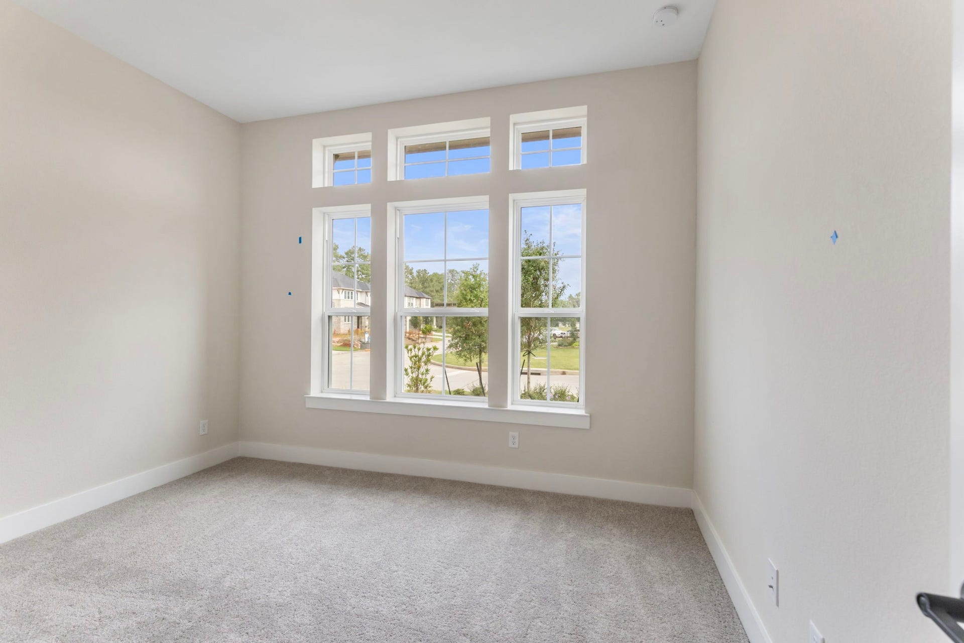 8143 Fenway Heights Dr, The Woodlands, TX 77389 Bright and inviting room featuring large windows that flood the space with natural light, complemented by soft carpet flooring and neutral walls.