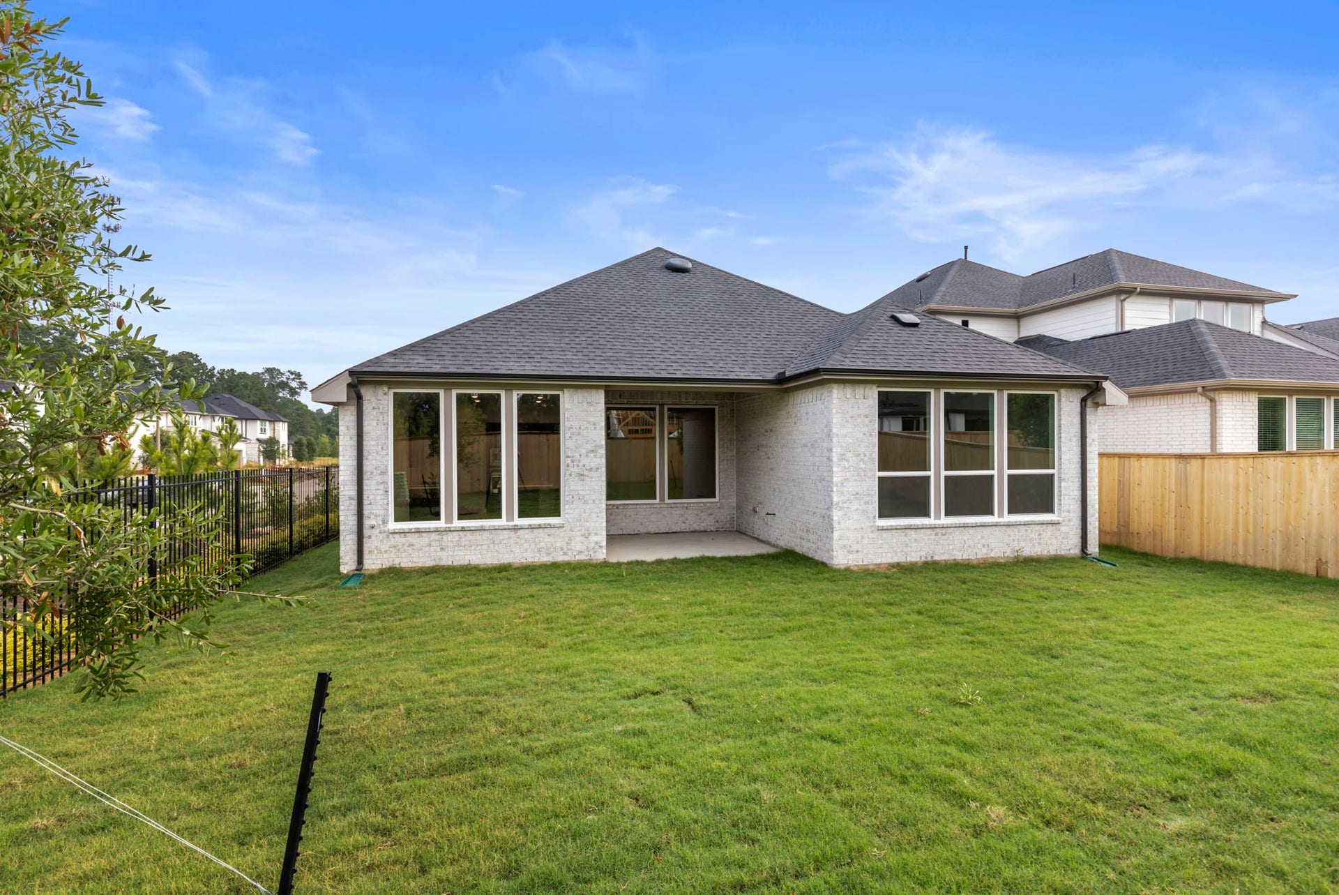 8143 Fenway Heights Dr, The Woodlands, TX 77389 Spacious backyard on a corner lot, featuring a covered patio.
