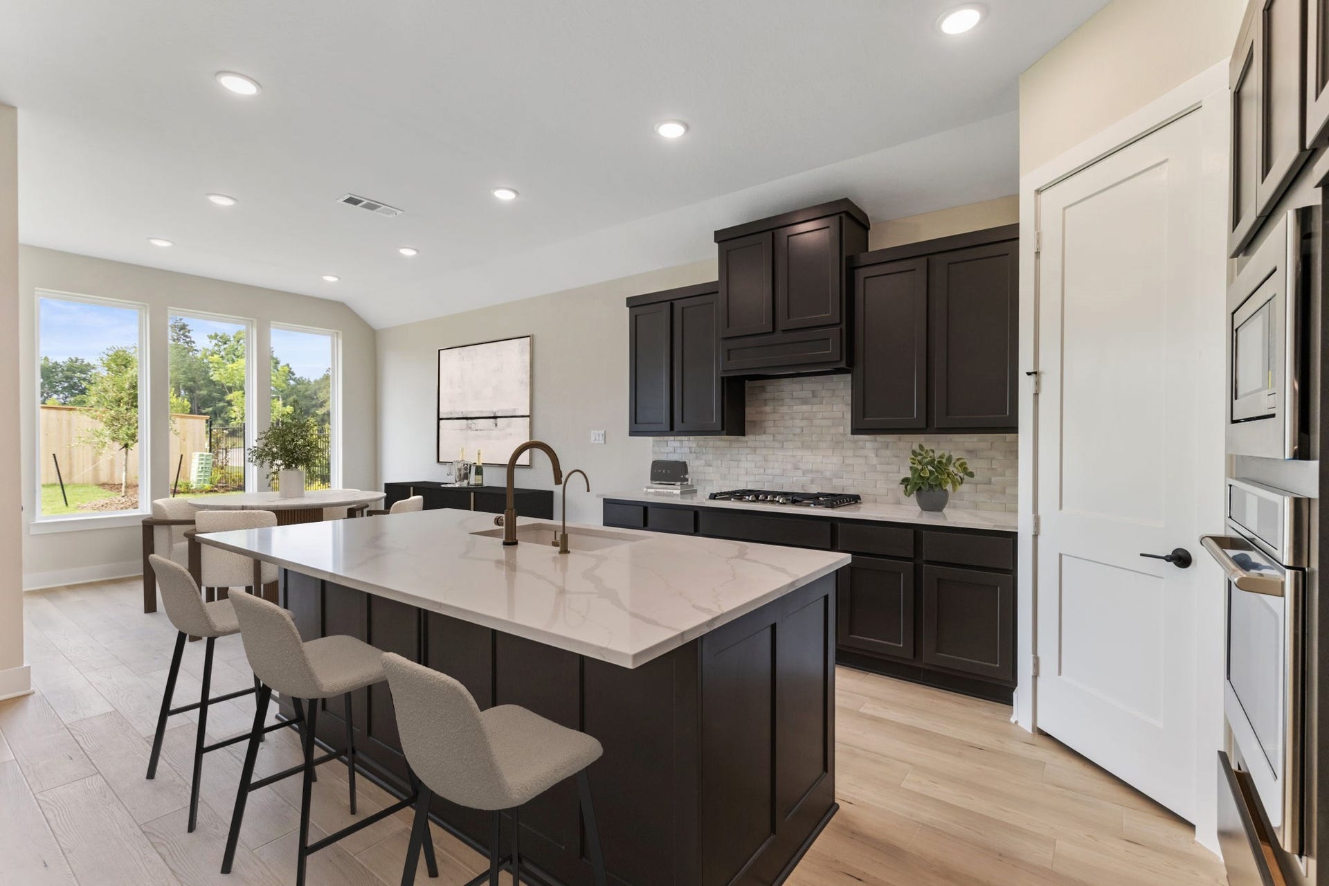 8143 Fenway Heights Dr, The Woodlands, TX 77389 Another view of the kitchen showing the bar area, offering a perfect blend of style and functionality.
