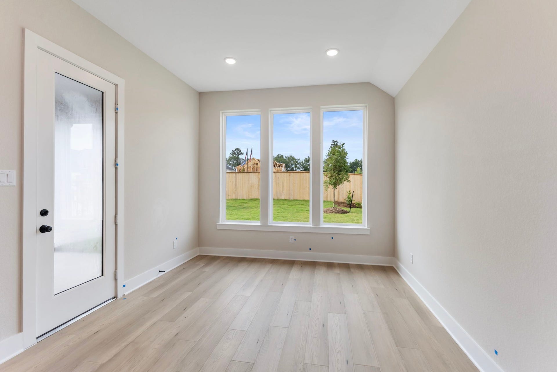 8143 Fenway Heights Dr, The Woodlands, TX 77389 Bright, inviting dining area with large windows offering views of a lush backyard, complemented by modern flooring.