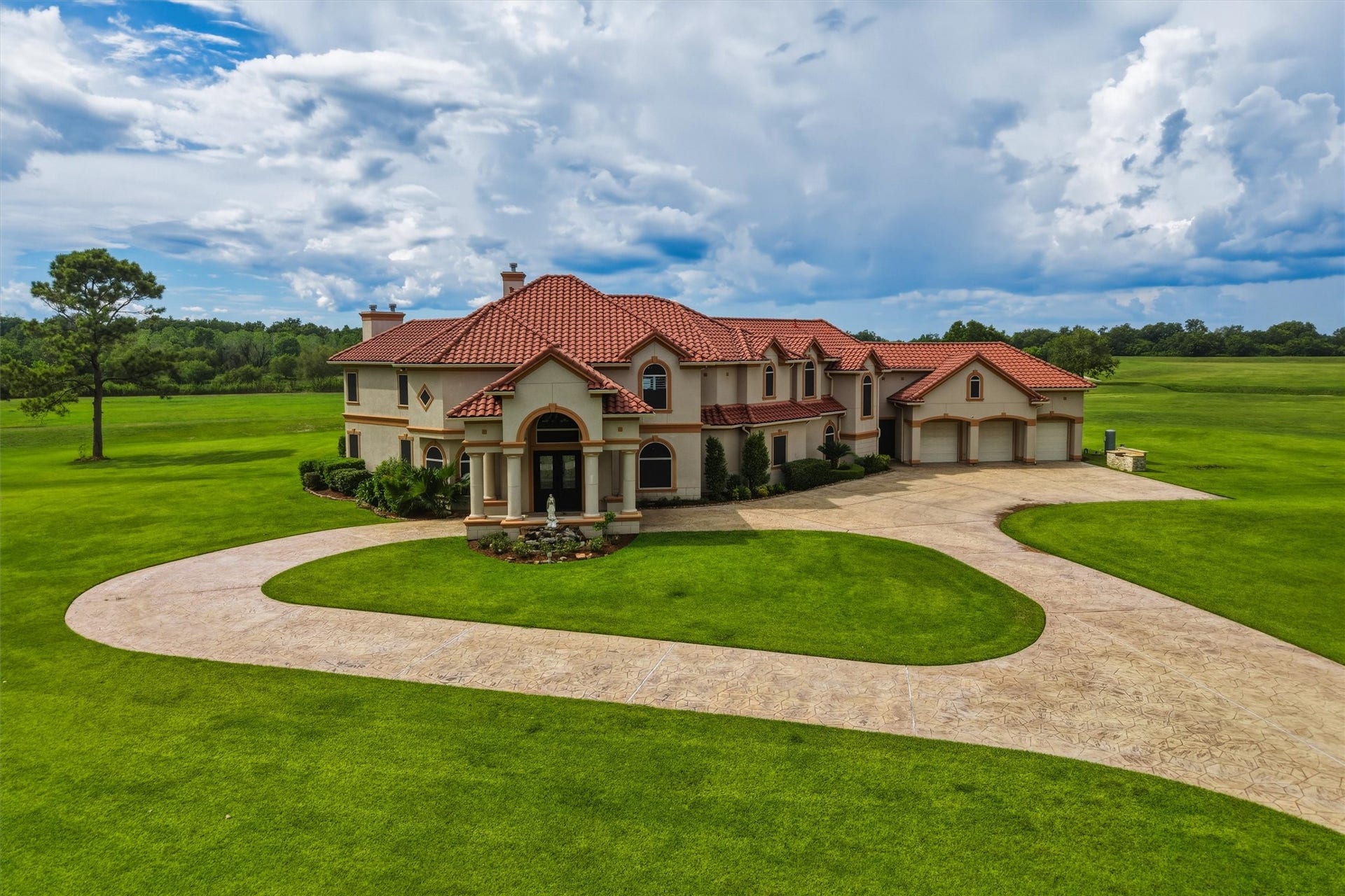 This rambling 2-Story Estate
captures the essence of a
Mediterranean Villa by eloquently
blending the stucco exterior with a
classic red tile roof. The circular drive
leads to the Porte Cochere that is
supported by impressive stone
columns