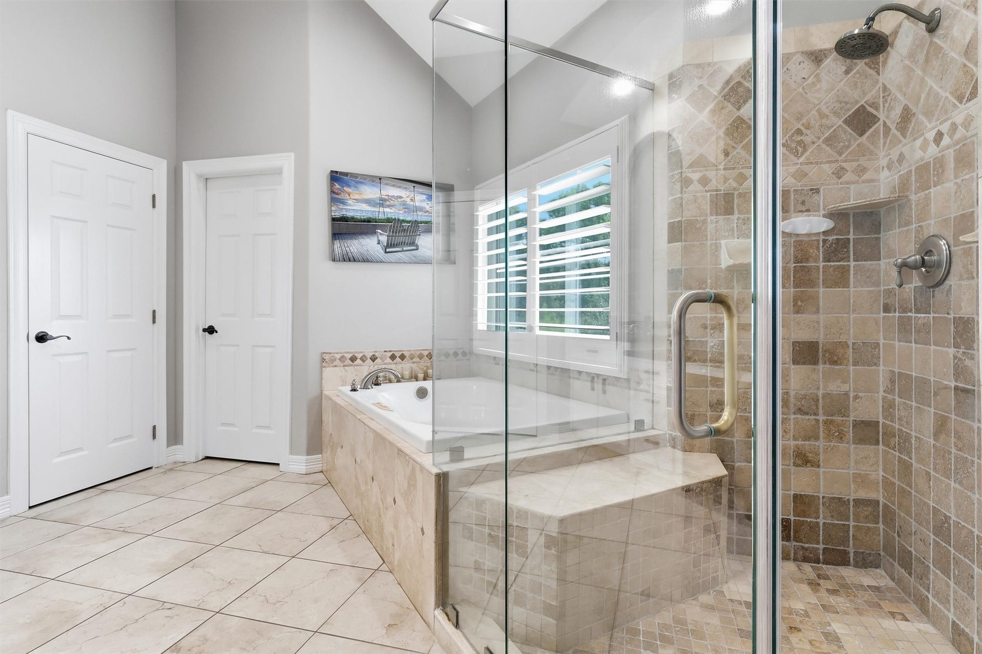 Relax in the deep soaking tub or the tiled walk-in shower, both accented with elegant stonework and a private window for natural light. This luxurious primary bath is the perfect place to unwind.