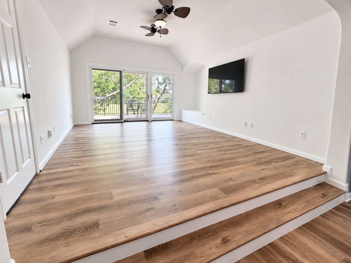 French doors from the raised game room lead to a generous balcony, creating an exceptional indoor-outdoor living space with breathtaking views of the Greatwood Golf Course.