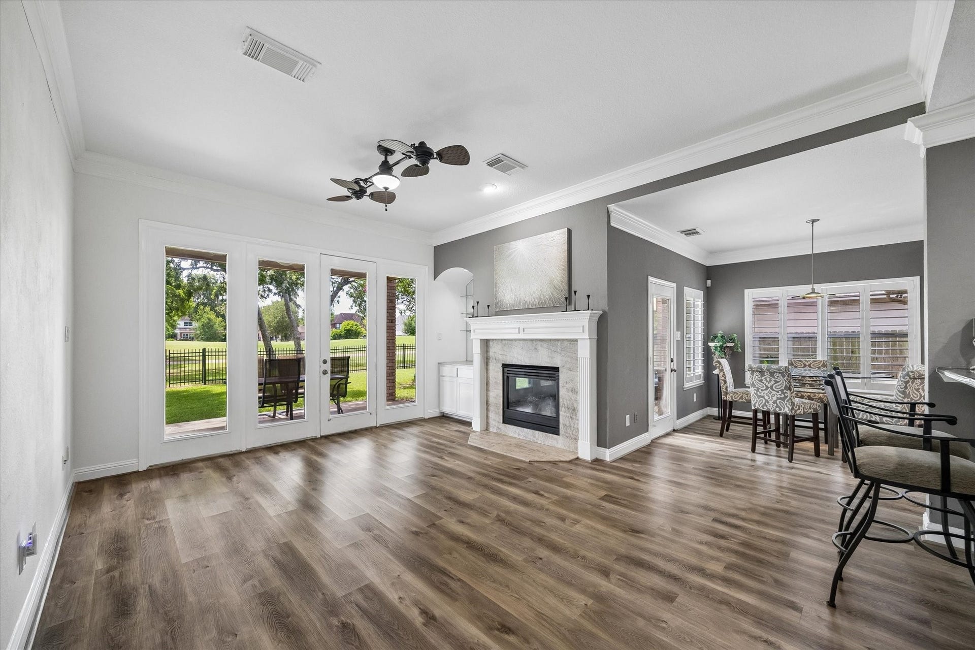 The light-filled family room is the heart of the home, featuring French doors, a stunning wall of windows, and breathtaking golf course views that create a warm, open, and inviting atmosphere.