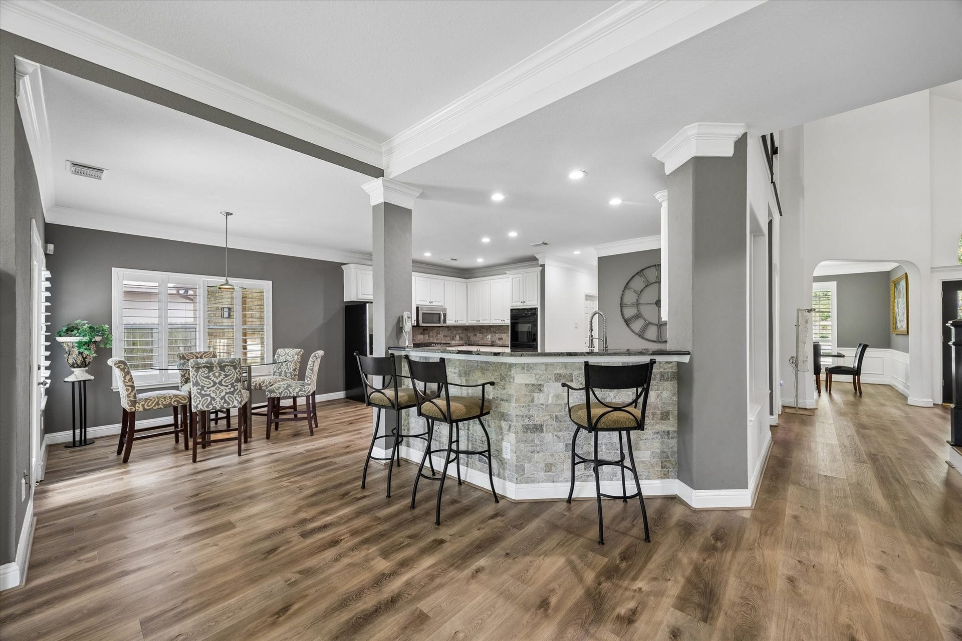 The expansive open-concept living and kitchen areas provide effortless flow for entertaining. The oversized island bar offers abundant seating, making it the perfect place for guests to gather while meals are prepared.