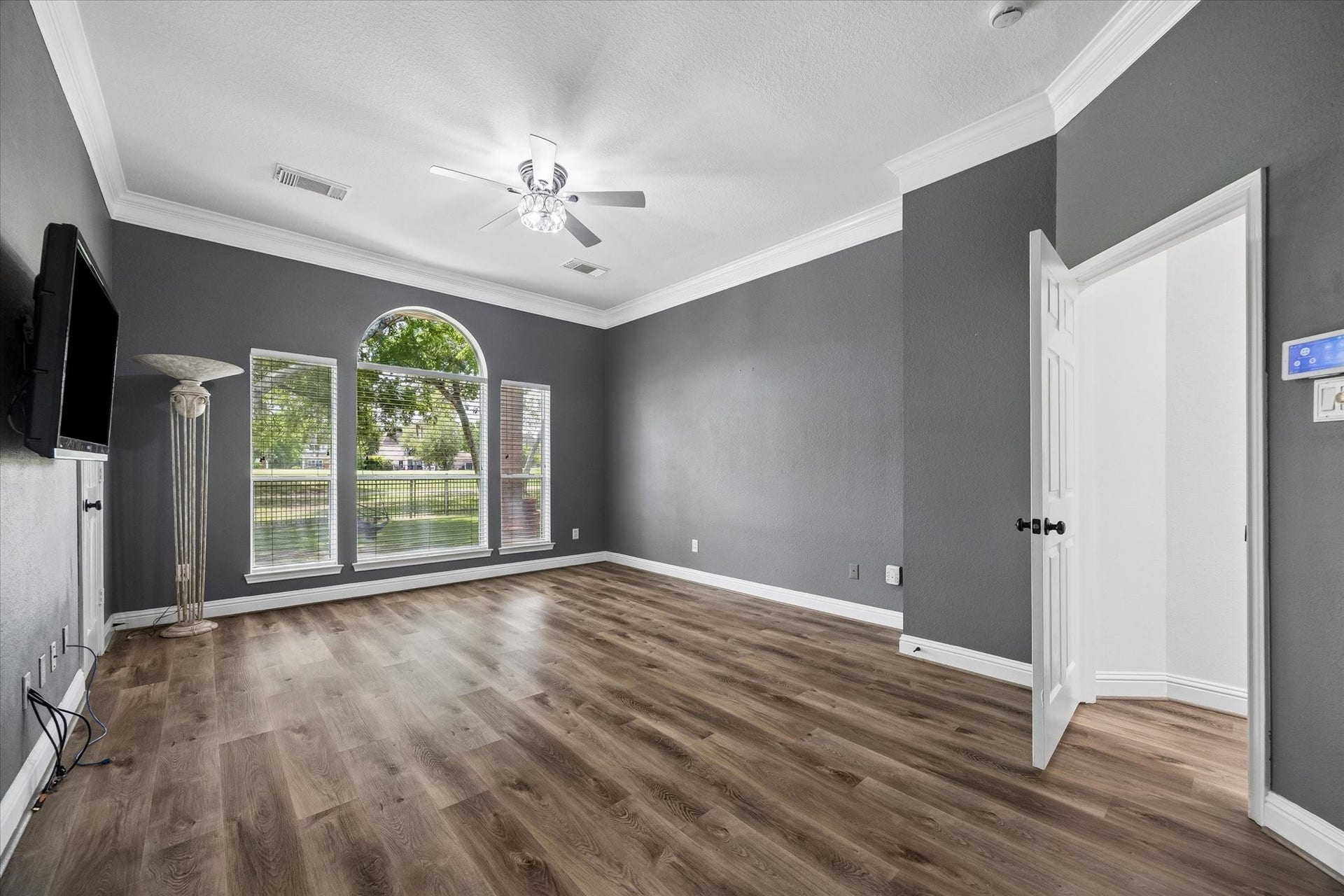 The spacious primary suite includes a well-appointed en suite bath, separate his-and-hers walk-in closets, and a mounted TV that conveys with the home. Thoughtfully updated with no carpet throughout, this home offers both style and easy maintenance.