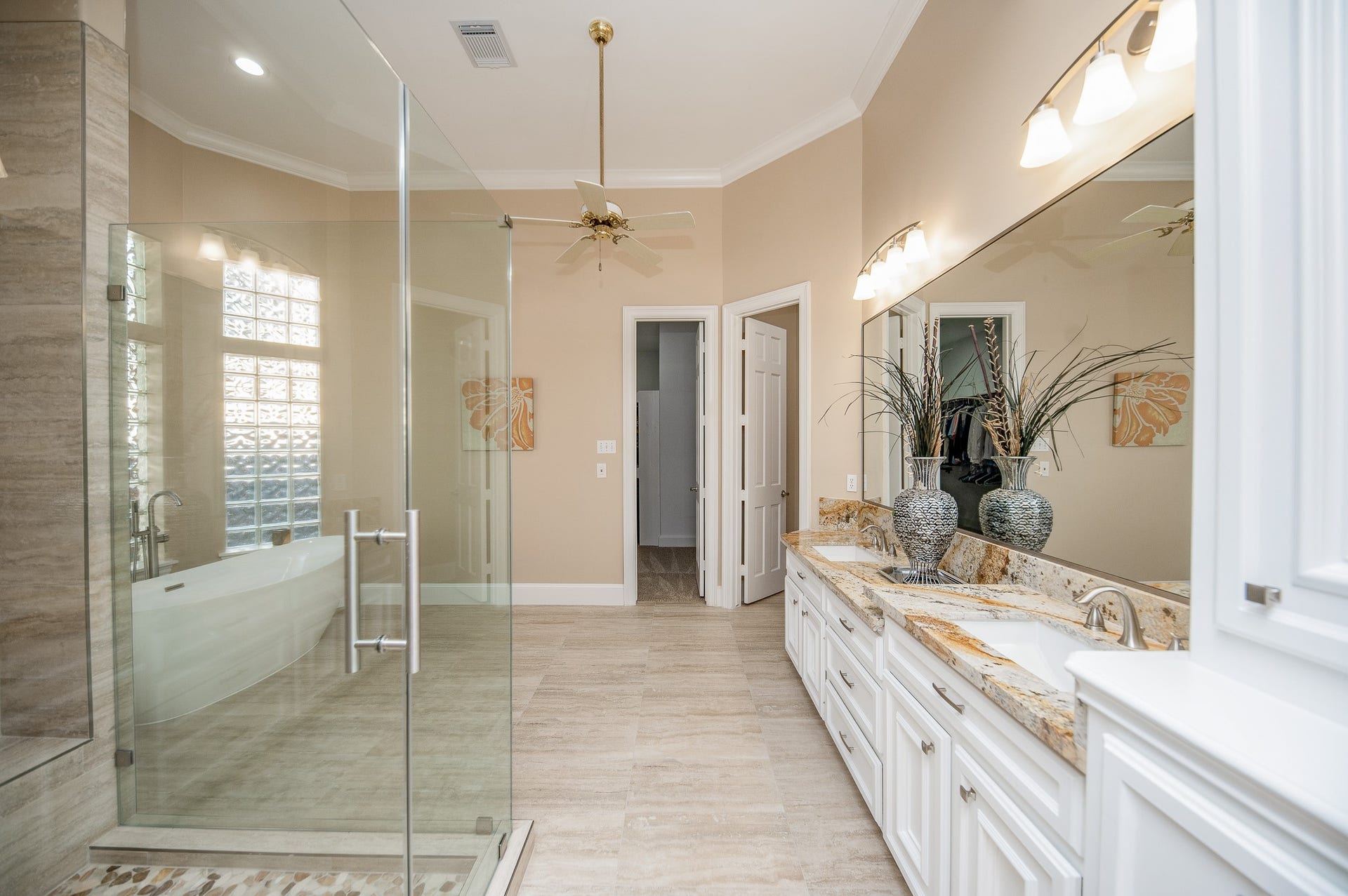 23014 Laguna Point Drive, Katy, TX 77450 Rain, shine --- or somewhere in between --- this primary ensuite bath will transport you to luxurious personal care; with fantastic floor space, dual sinks, wall-wide mirror and delicate lighting, above; and rimless walk-in shower and free standing soaking tub, left.