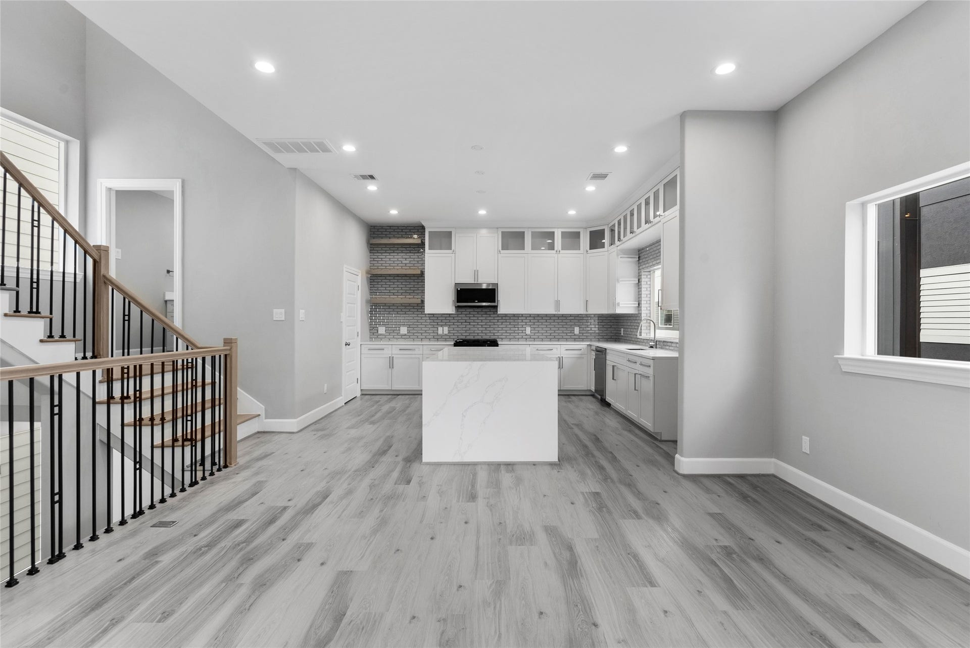 1122 W 16th Street, #B, Houston, TX 77008 View of kitchen from the dining area with access to the powder room on the landing of the stairs