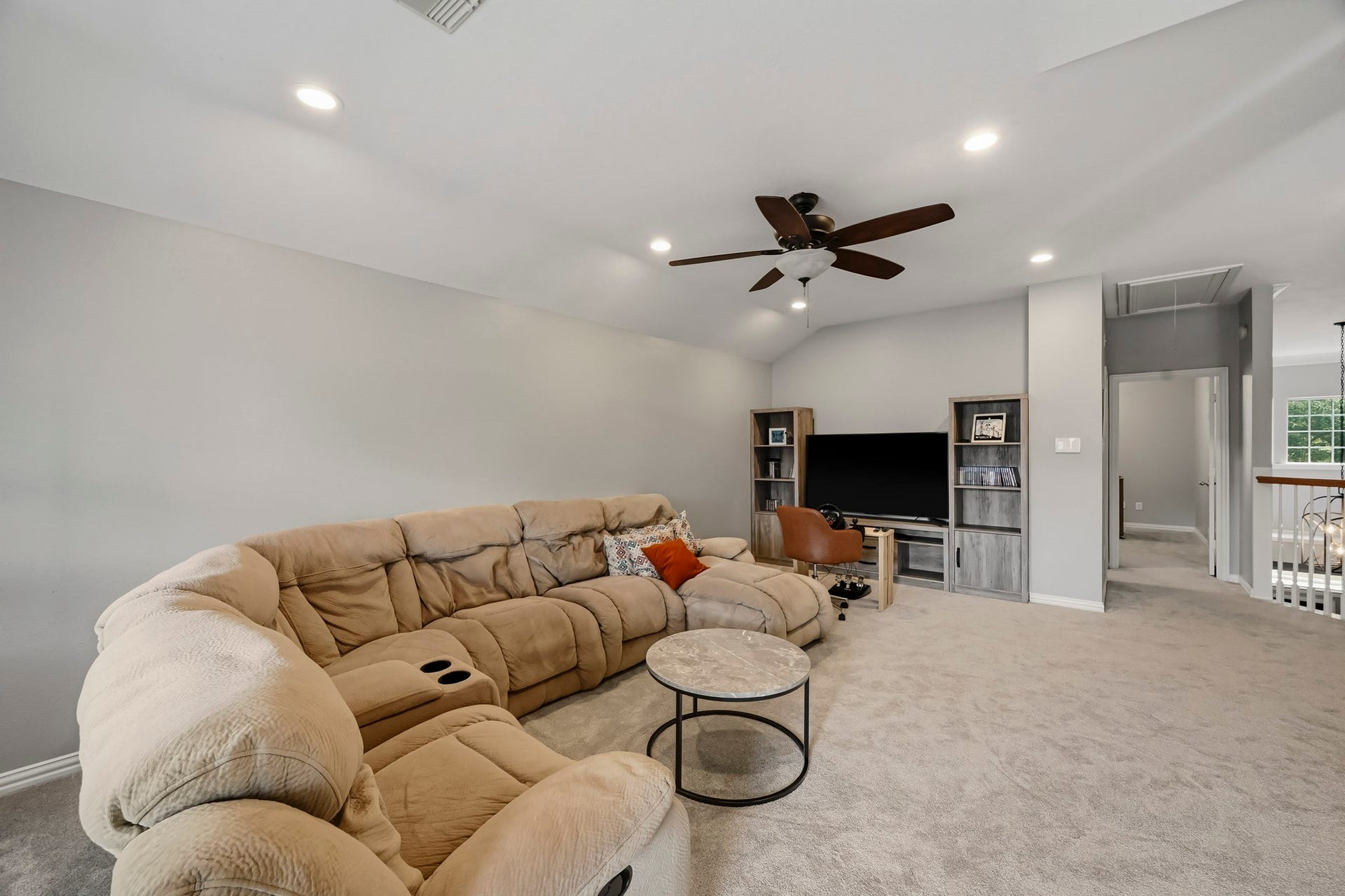 5702 Misty Island Court, Katy, TX 77494 Spacious living area with plush sectional seating, recessed lighting, and a ceiling fan, perfect for relaxation and entertainment.