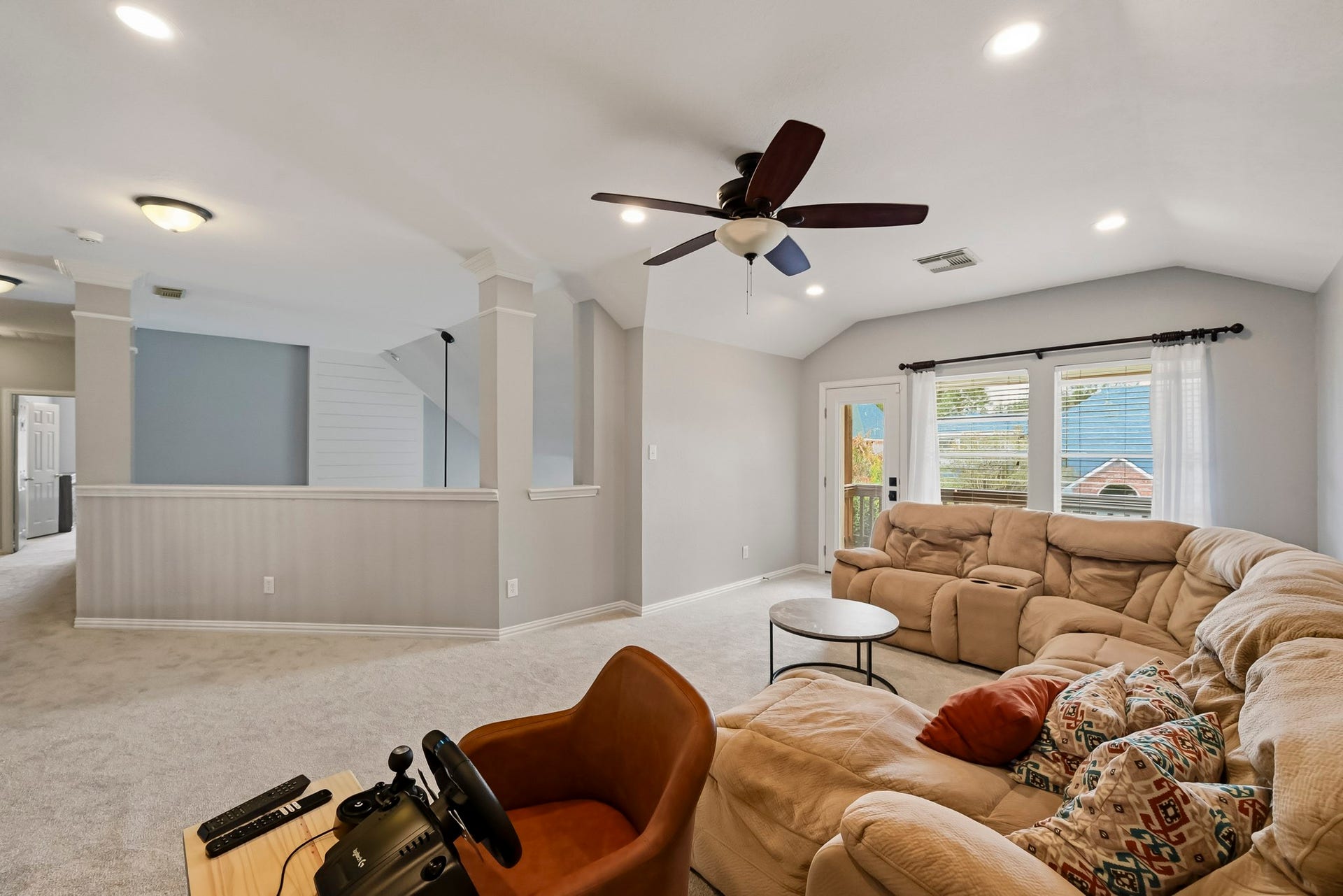 5702 Misty Island Court, Katy, TX 77494 Spacious and inviting living area with plush sectional seating, abundant natural light from large windows, and a ceiling fan for comfort. Ideal for relaxation and entertainment.