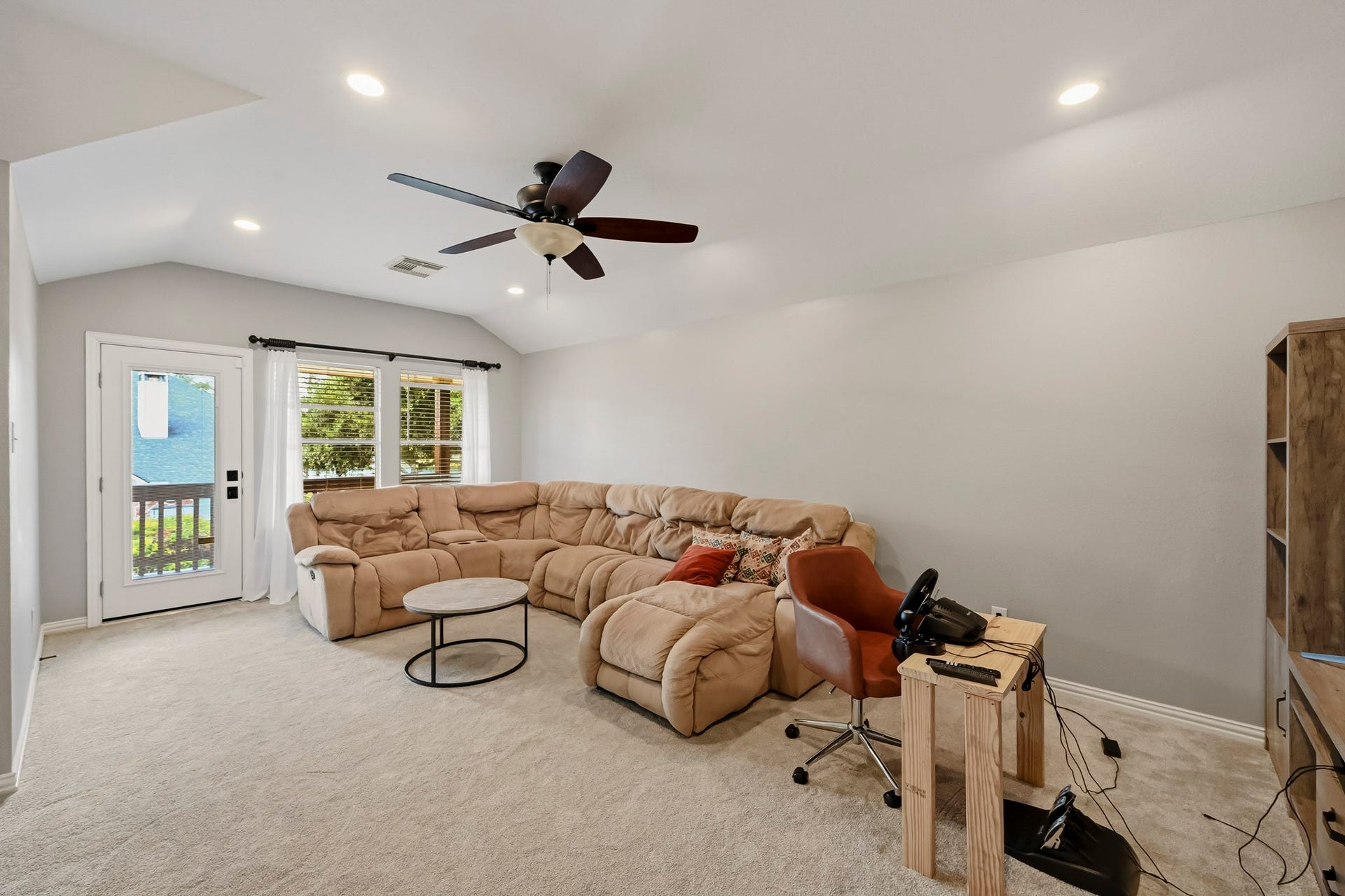 5702 Misty Island Court, Katy, TX 77494 Spacious living area with plush sectional seating, abundant natural light, and access to a cozy balcony through French doors.