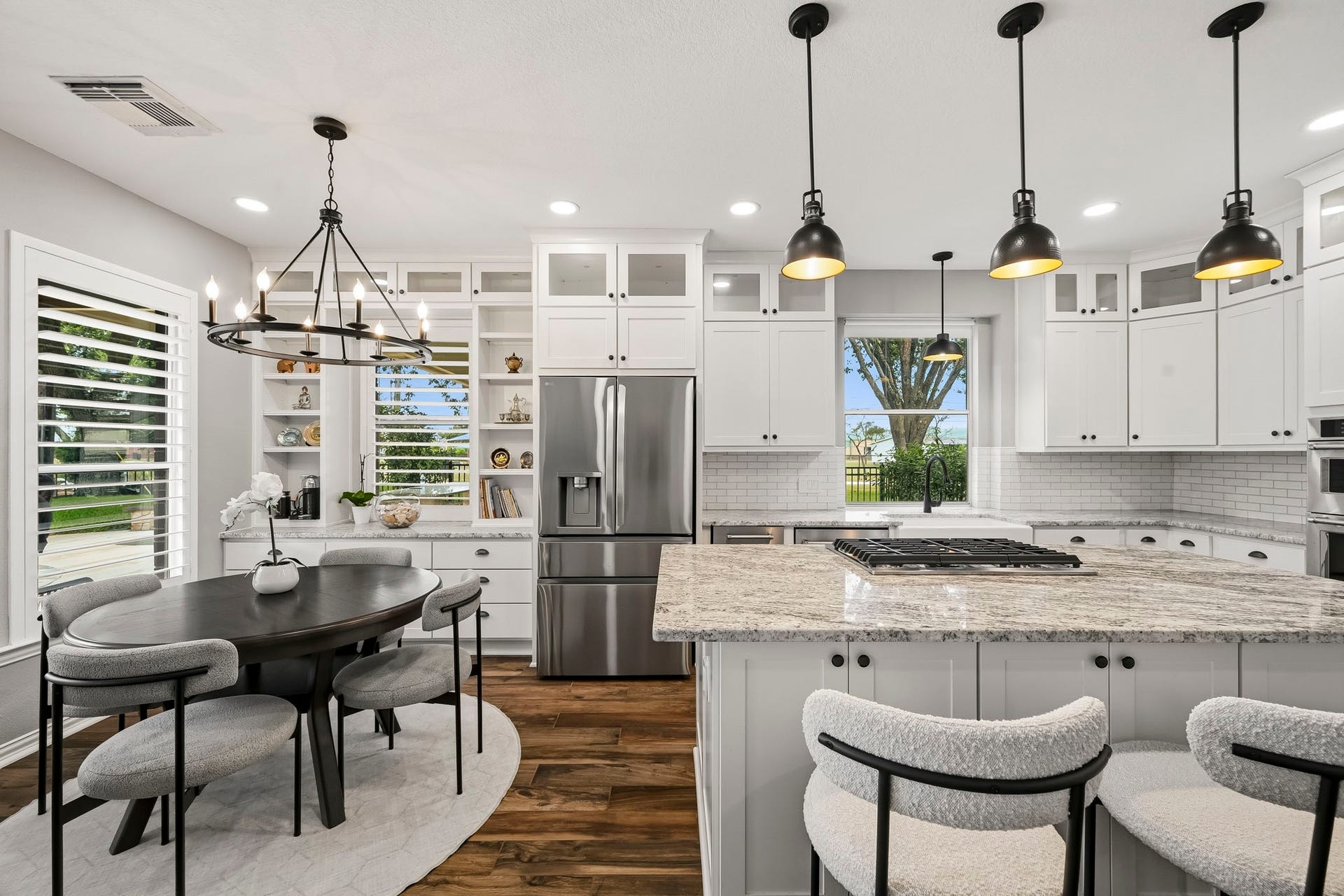 5702 Misty Island Court, Katy, TX 77494 Stunning kitchen with elegant pendant lighting, a spacious granite island, and sleek stainless steel appliances. The cozy breakfast nook features a chic chandelier, surrounded by ample natural light from large windows.