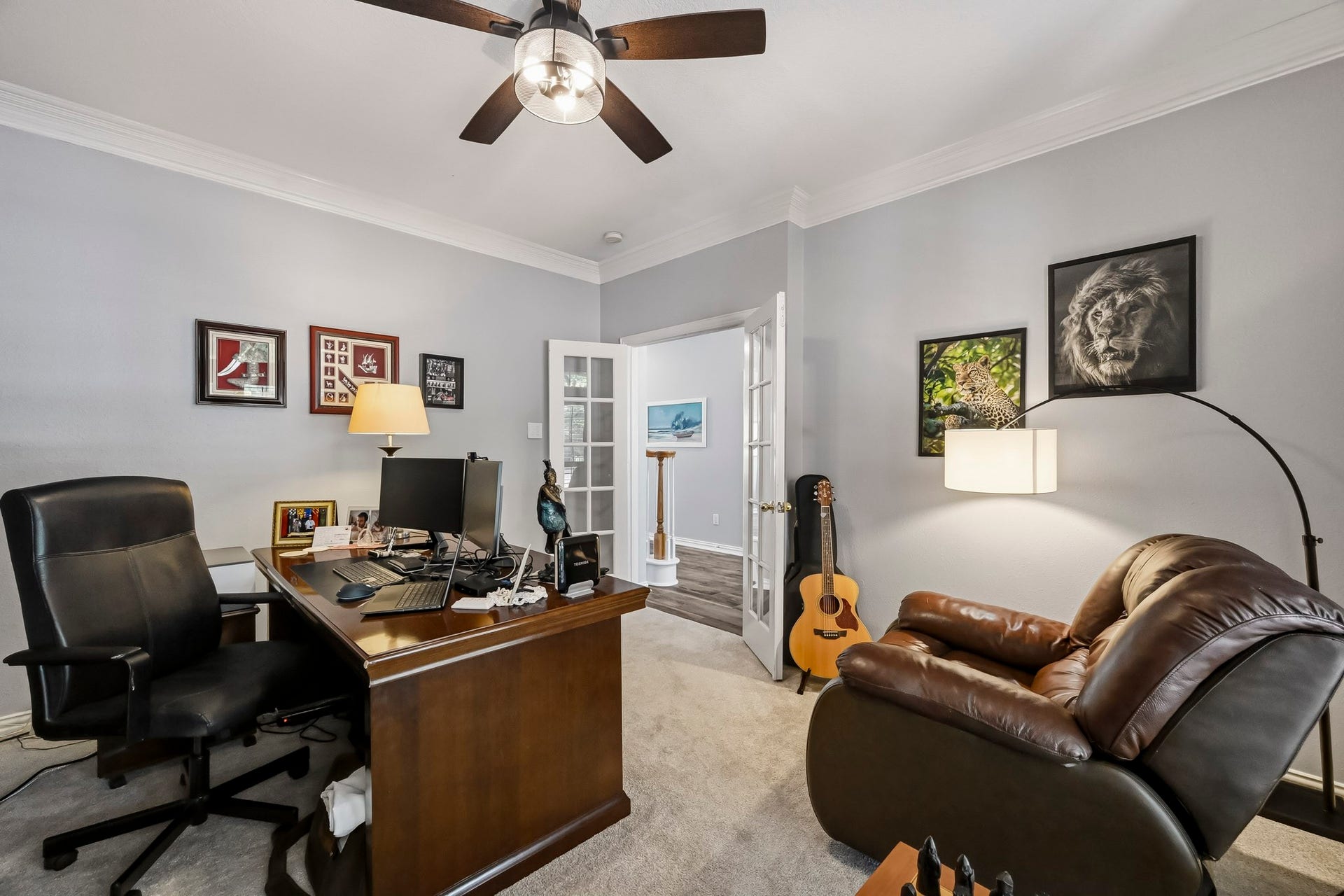 5702 Misty Island Court, Katy, TX 77494 Elegant home office featuring a rich wooden desk, cozy leather seating, and stylish decor. Natural light flows through French doors, enhancing the inviting atmosphere.