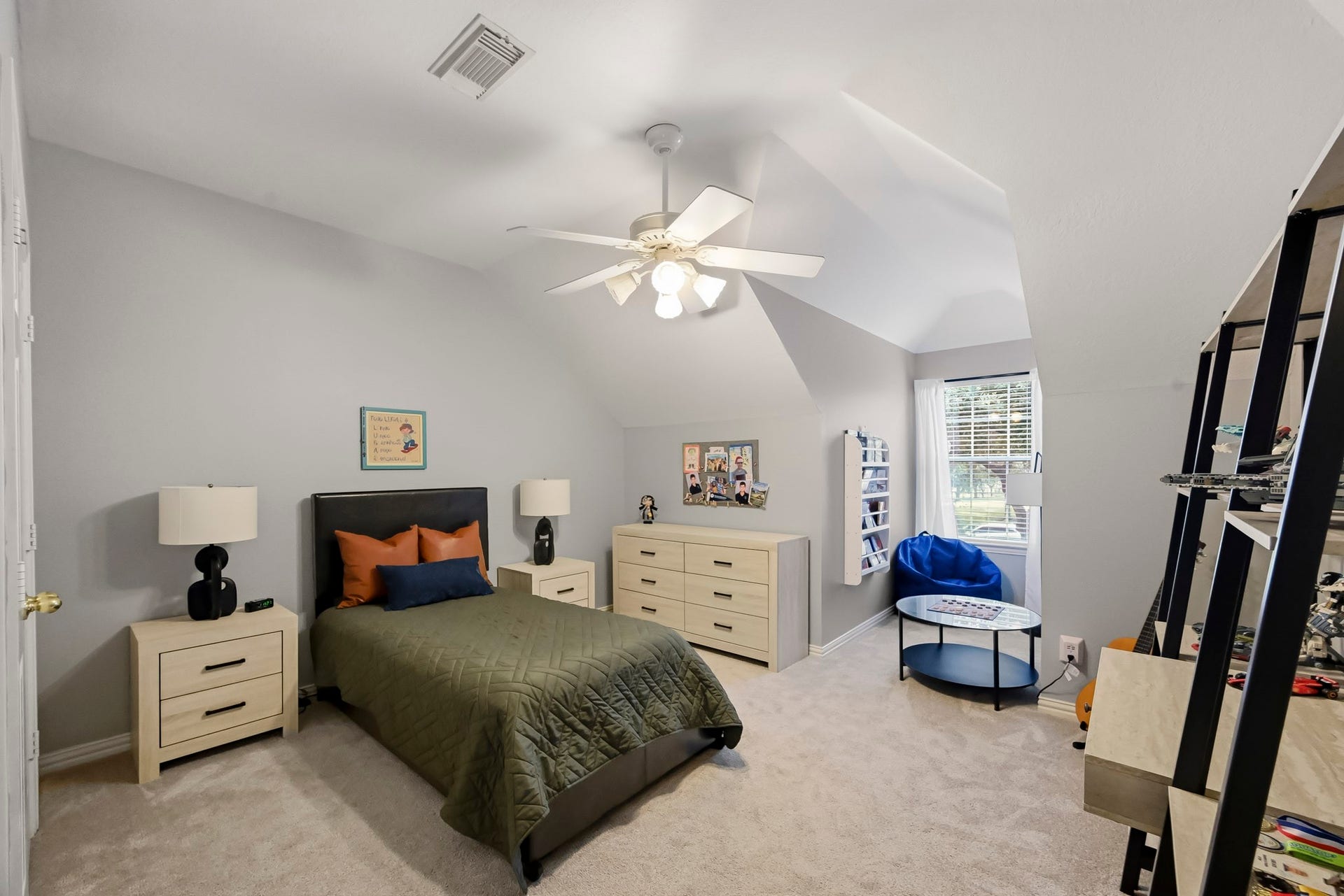 5702 Misty Island Court, Katy, TX 77494 Cozy bedroom with sloped ceilings, featuring a comfortable single bed, ample storage with dressers, and a reading nook by the window.