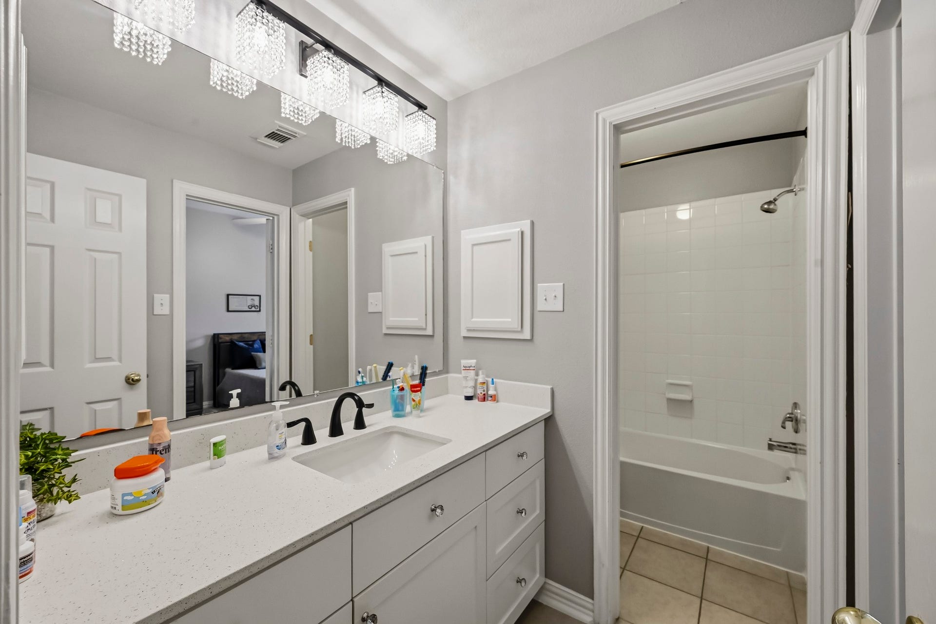 5702 Misty Island Court, Katy, TX 77494 Bright and modern bathroom featuring a sleek double vanity with ample storage, contemporary fixtures, and a tiled shower-tub combo for versatile use.