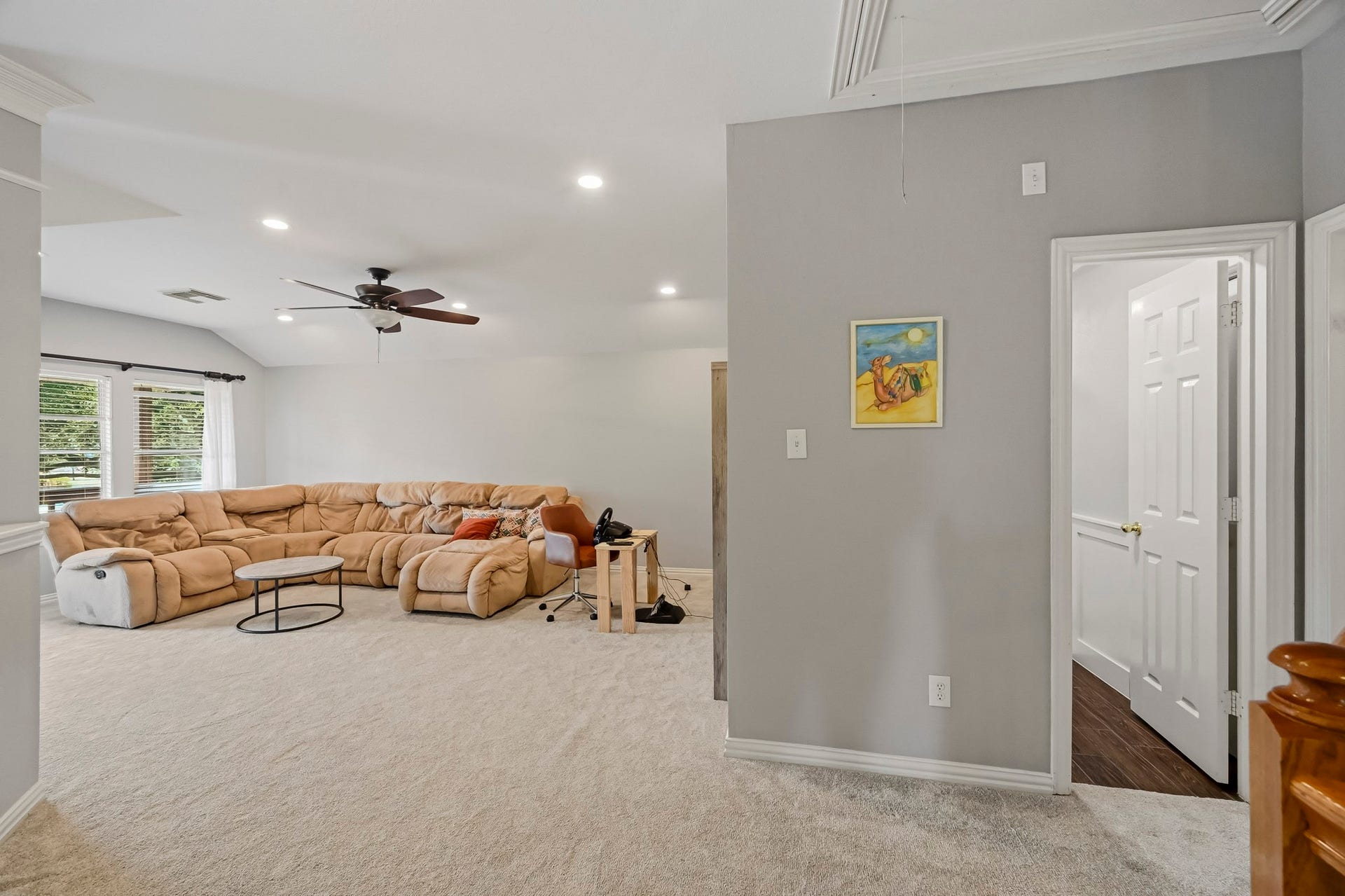 5702 Misty Island Court, Katy, TX 77494 Spacious living area featuring plush carpeting, a large sectional sofa, and ample natural light from wide windows, perfect for relaxation and entertainment.