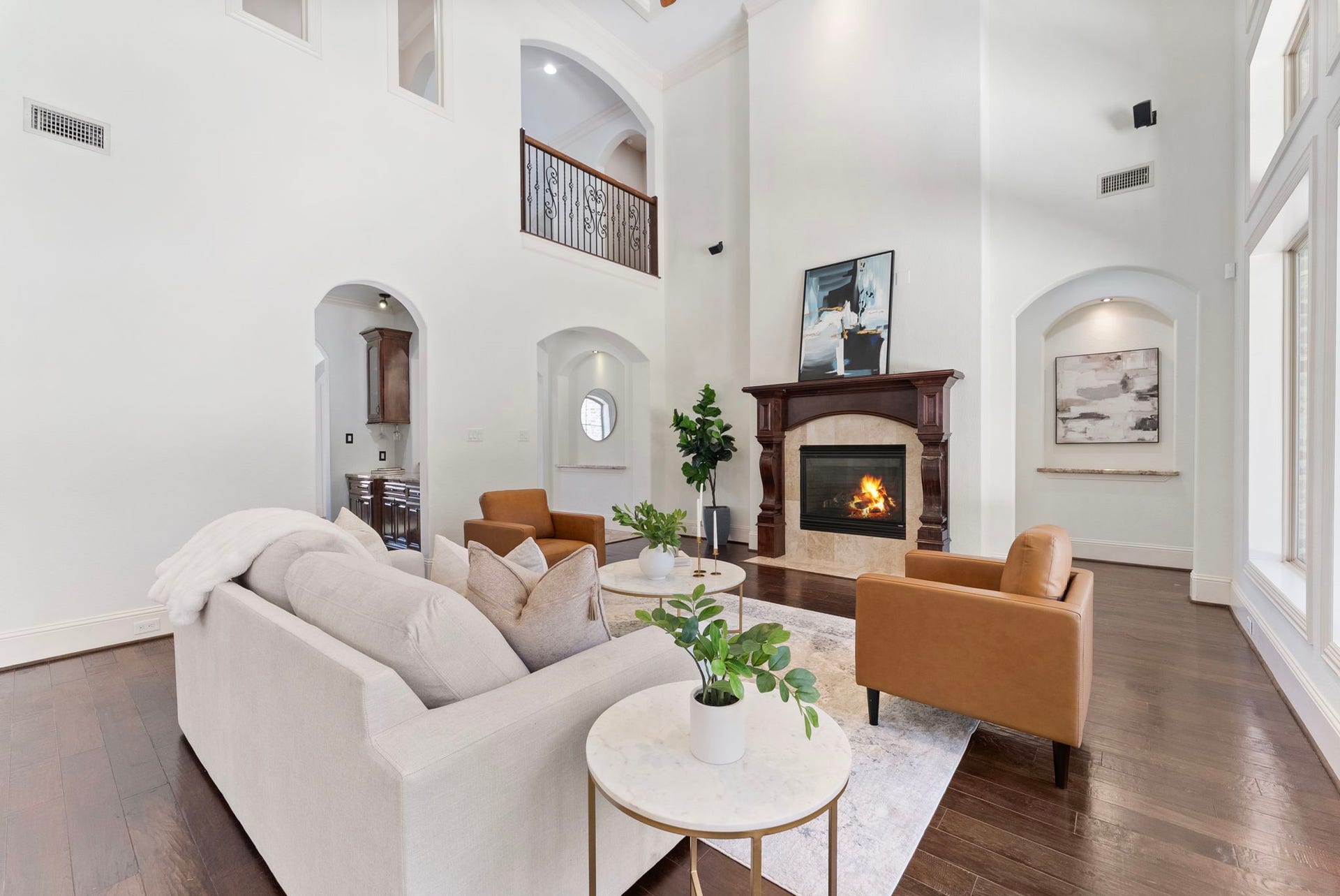 27507 Hunter Creek Court, Spring, TX 77386 Living area centered around a fireplace with hardwood flooring and open two-story architecture.