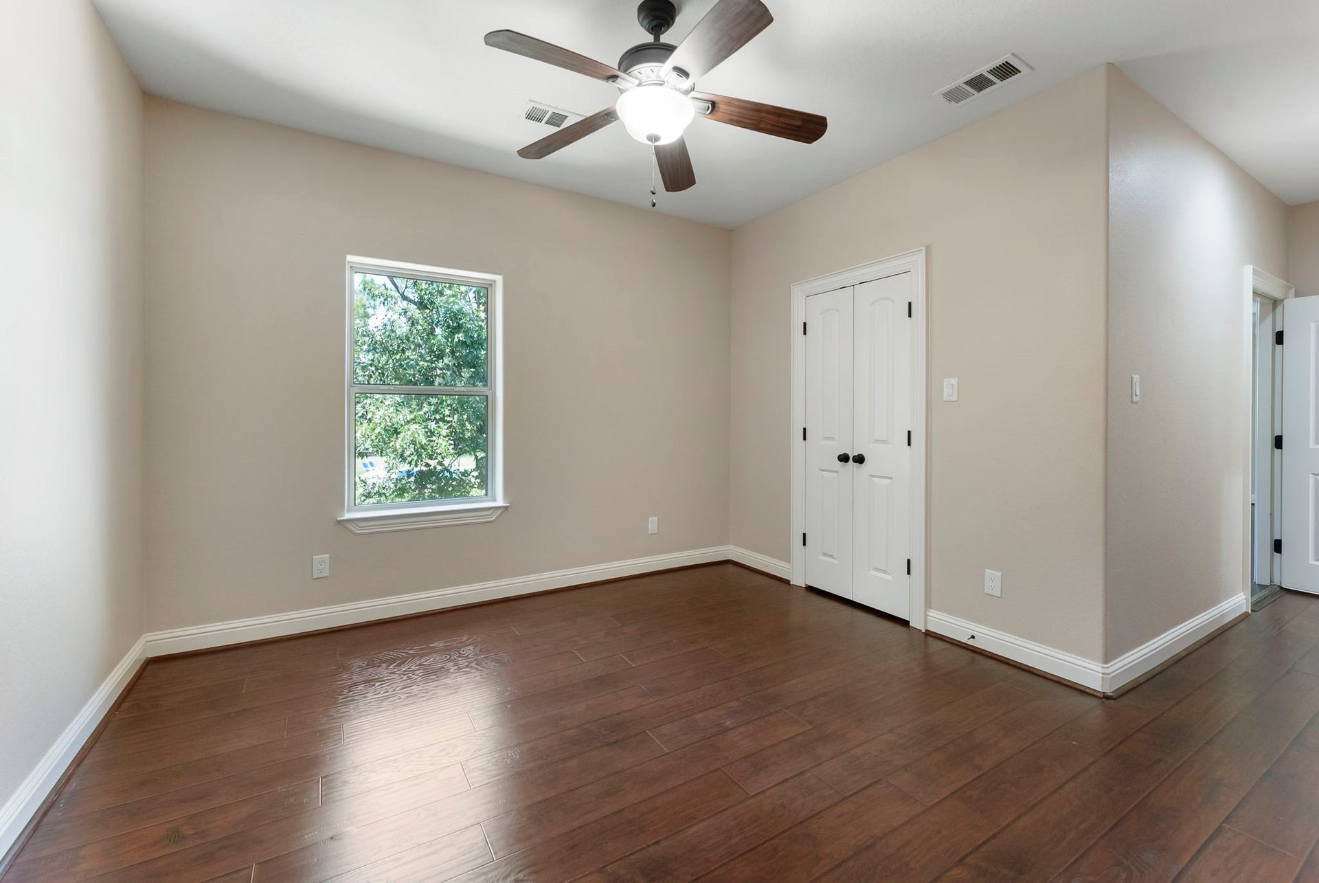 27507 Hunter Creek Court, Spring, TX 77386 Secondary bedroom with hardwood flooring, ceiling fan and large window.